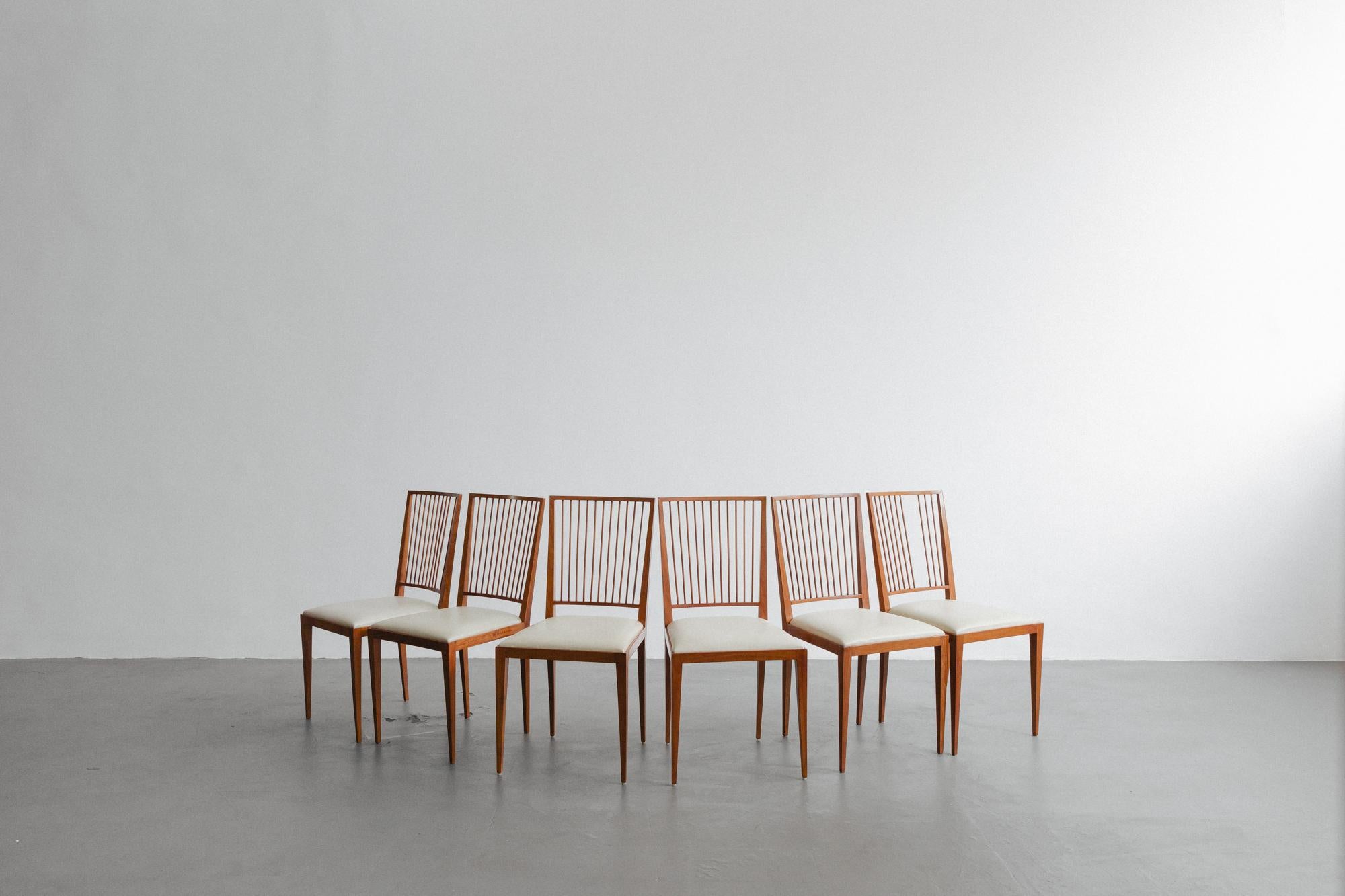 This exquisitely crafted chair made of Perobinha-do-campo Wood, designed by Joaquim Tenreiro (1906-1992), evokes a refined coexistence of traditional values and modern aesthetics. Its delicate shapes, with the backs of thin sticks and the carved,