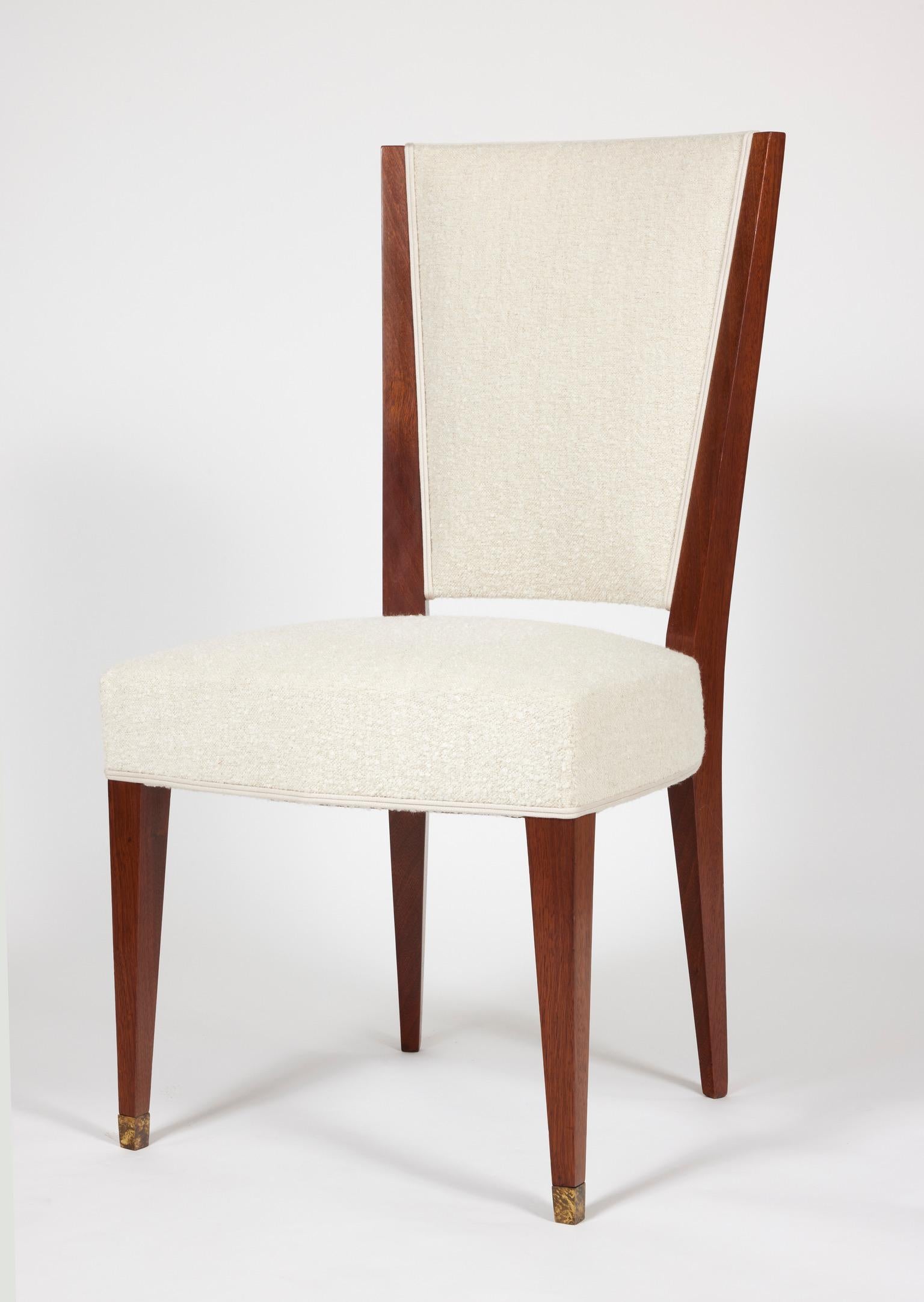 Suite of six chairs in walnut. Front legs with patinated brass shoes. White fabric.