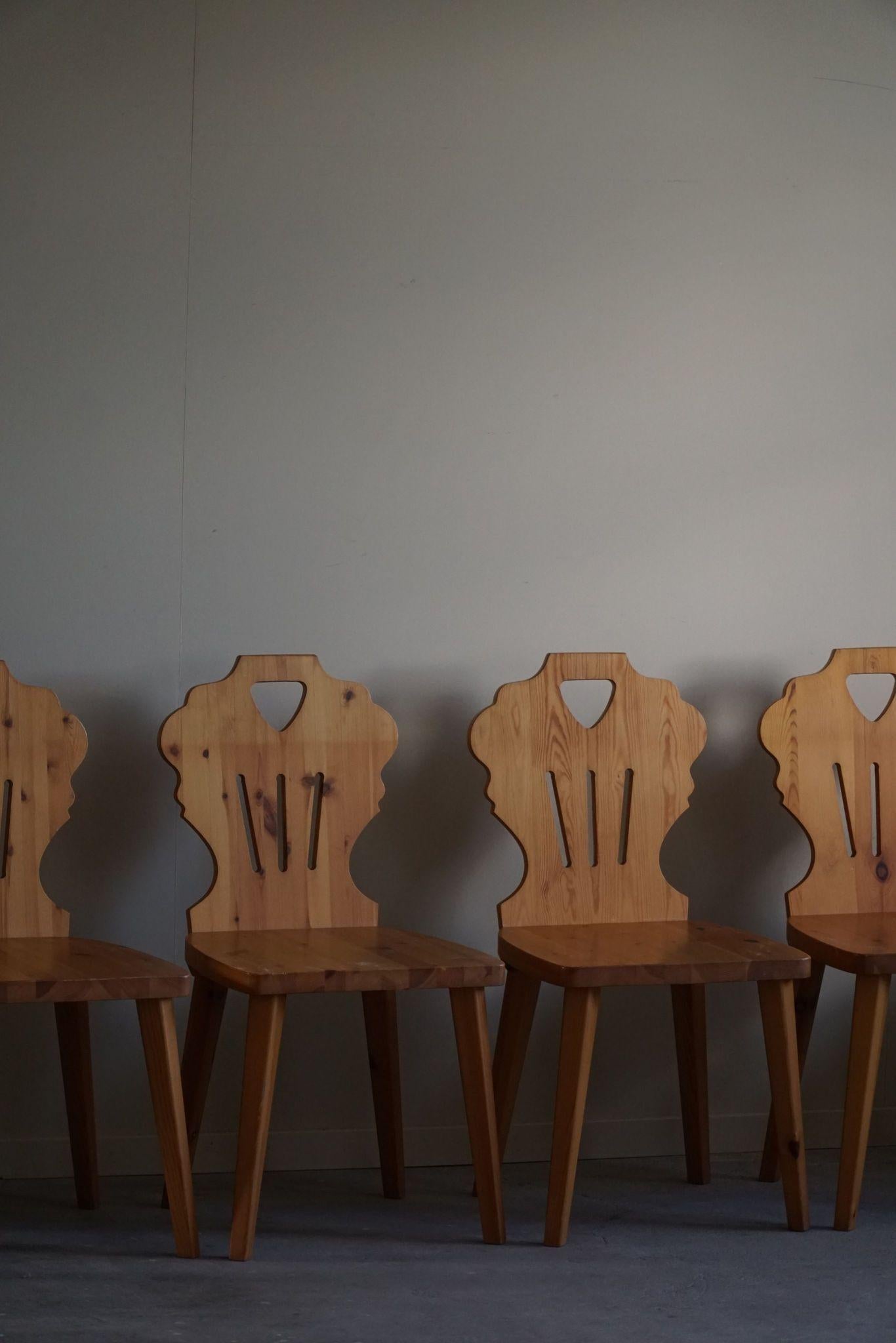 A beautiful set of 6 sculptural dining chairs in solid pine with a fine carved backrest. Handcrafted by a Swedish Cabinetmaker in the 1960s, made in the style of Carl Malmsten. These dining chairs have a strong impression that pairs well with many