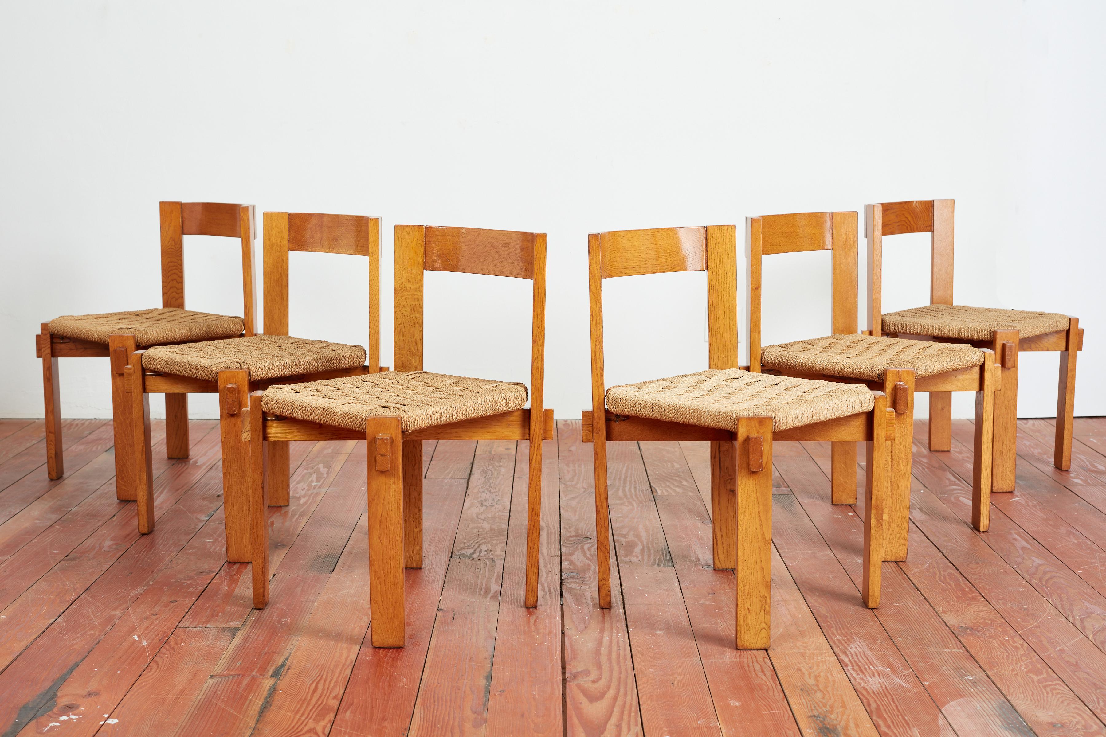 Set of 6 dining chairs attributed to Charlotte Perriand with woven straw seats and wonderful corner joints. 
Original rich patina to wood. 
France, 1960s