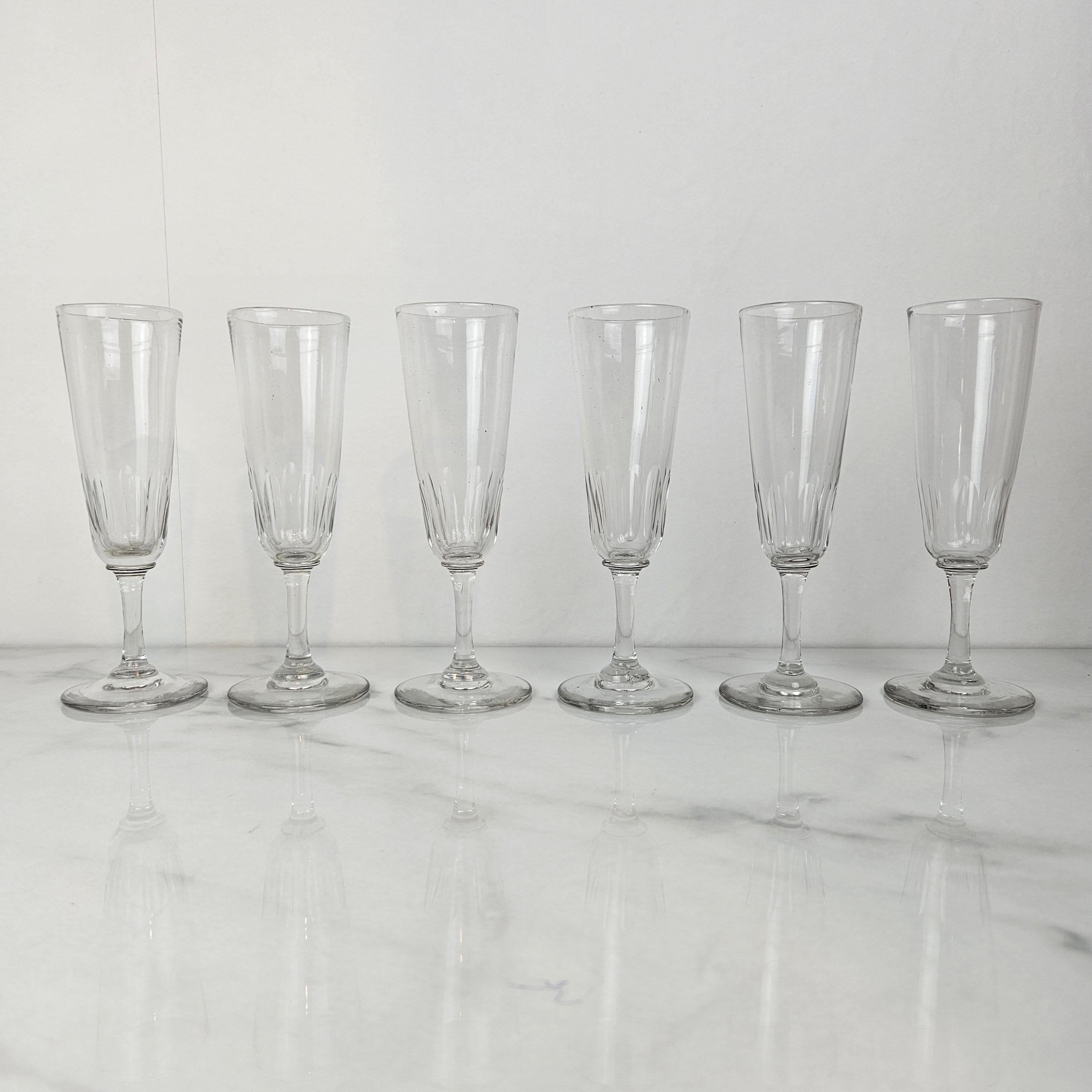 Un ensemble raffiné de six coupes à champagne françaises anciennes, fabriquées en verre clair vers 1880.
Chaque flûte présente une coupe inférieure magnifiquement taillée et une tige élancée, offrant à la fois un intérêt visuel et une silhouette