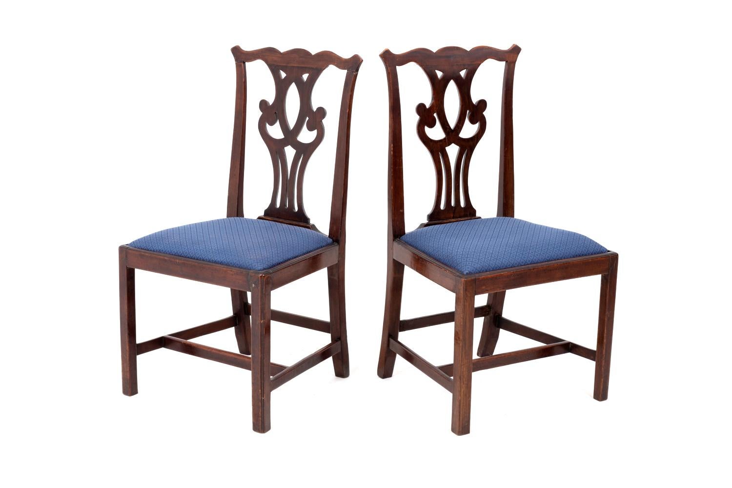 Set of six Chippendale chairs in walnut standing on four straight legs linked each other by three stretchers on sides and on the back and a transversal bar. Openwork back with a stylized motif of scrolls. Seat garnishes with a royal blue fabric with