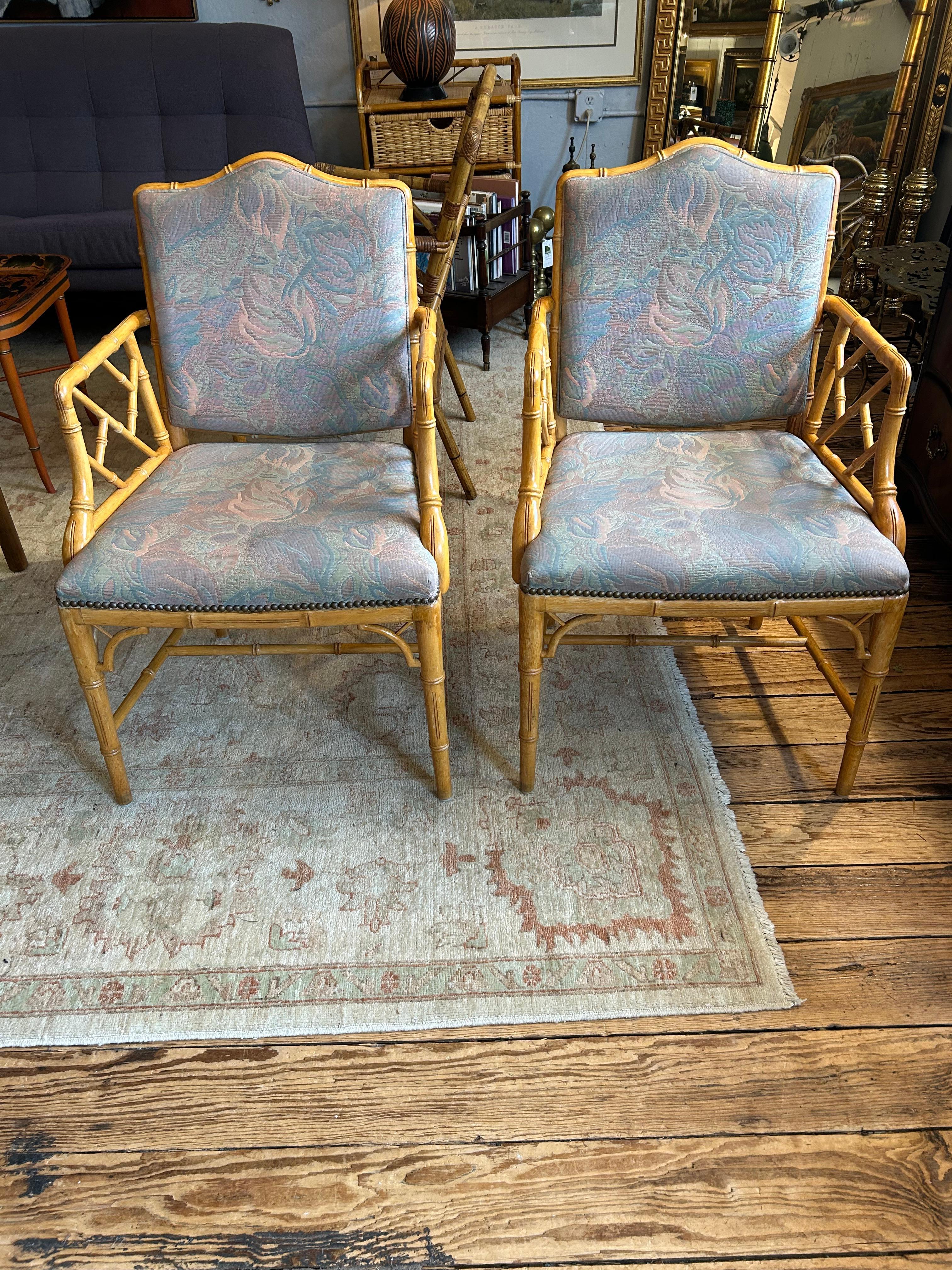 Chaises de salle à manger classiques en bambou, de style Chippendale, avec des accoudoirs et une touche asiatique.  Les tissus d'ameublement sont principalement des tissus floraux gris-bleu avec une impression de tapisserie.
Quelques marques ici et
