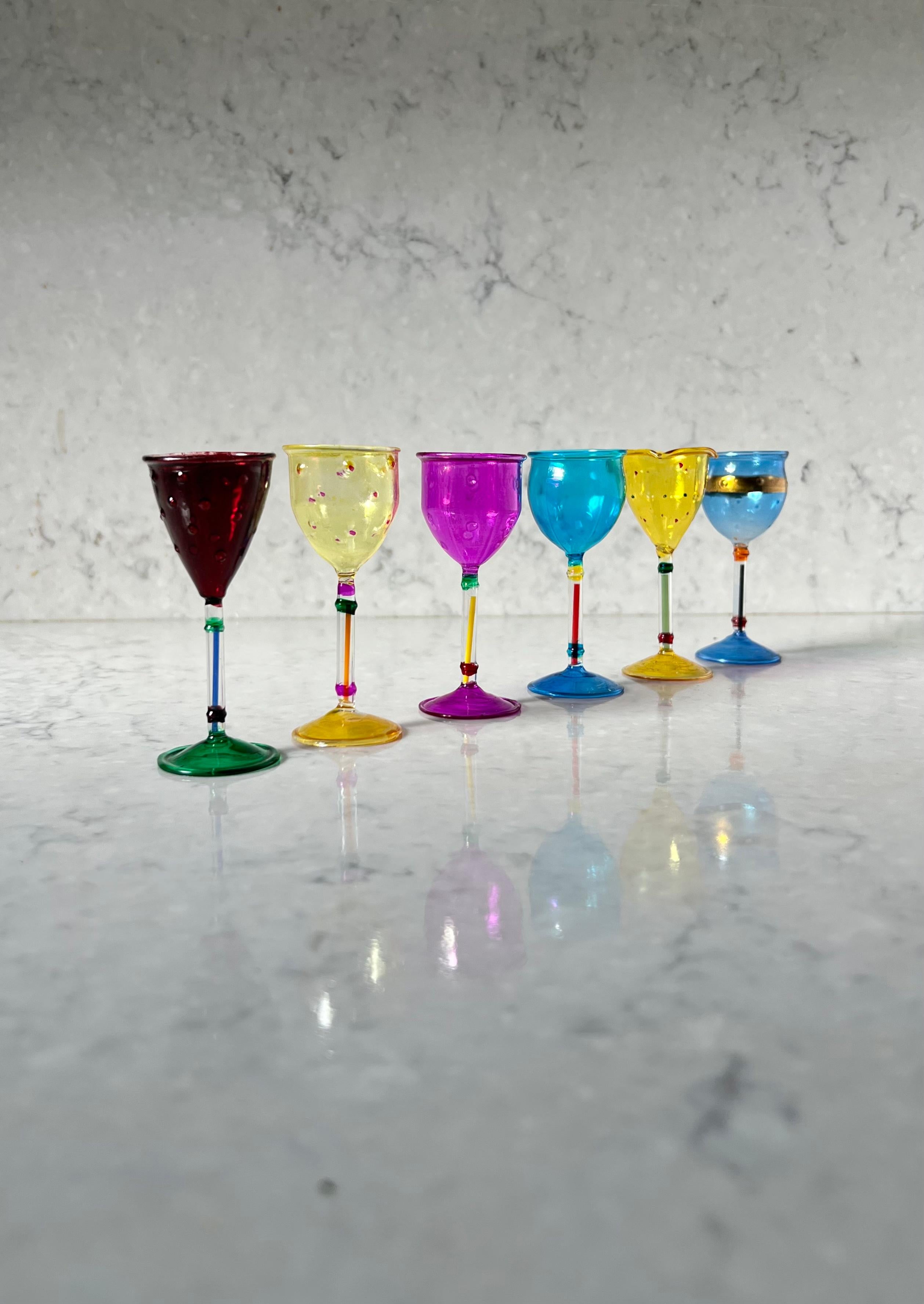 A set of six vintage Venetian cordial glasses by Antonio Salviati for Venezia, 20th century. Laid in ivory silk within a midnight blue velvet box with tooth-clasp opening. Glasses are hand-painted in colorful tones of merlot, mustard, magenta, and