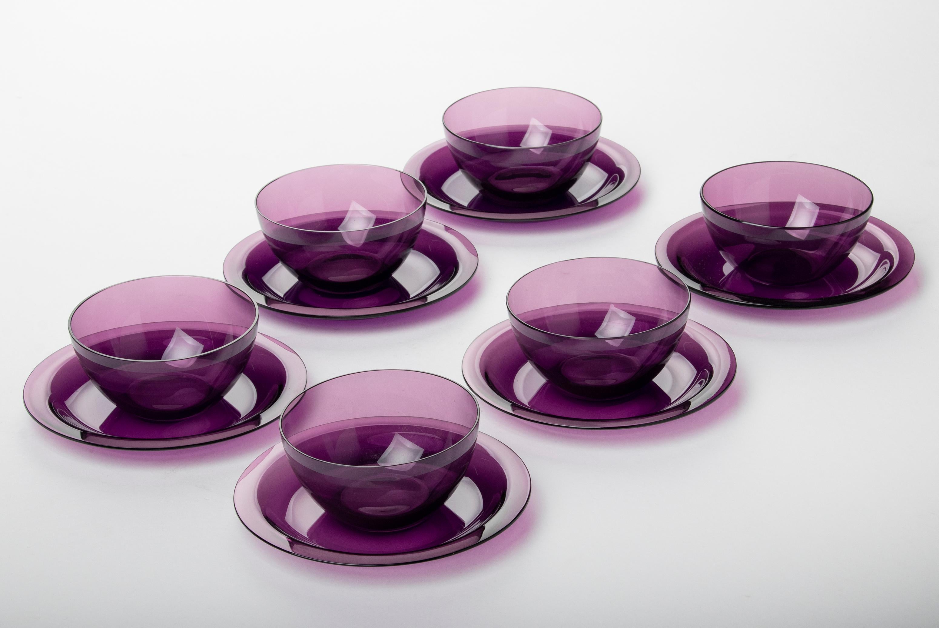 Beautiful set of 6 crystal fruit bowls with saucers from the French brand Lalique. The bowls have a simple, elegant design that emphasizes the top quality of the crystal. The purple color is also special. The dishes were made around 1950. All parts