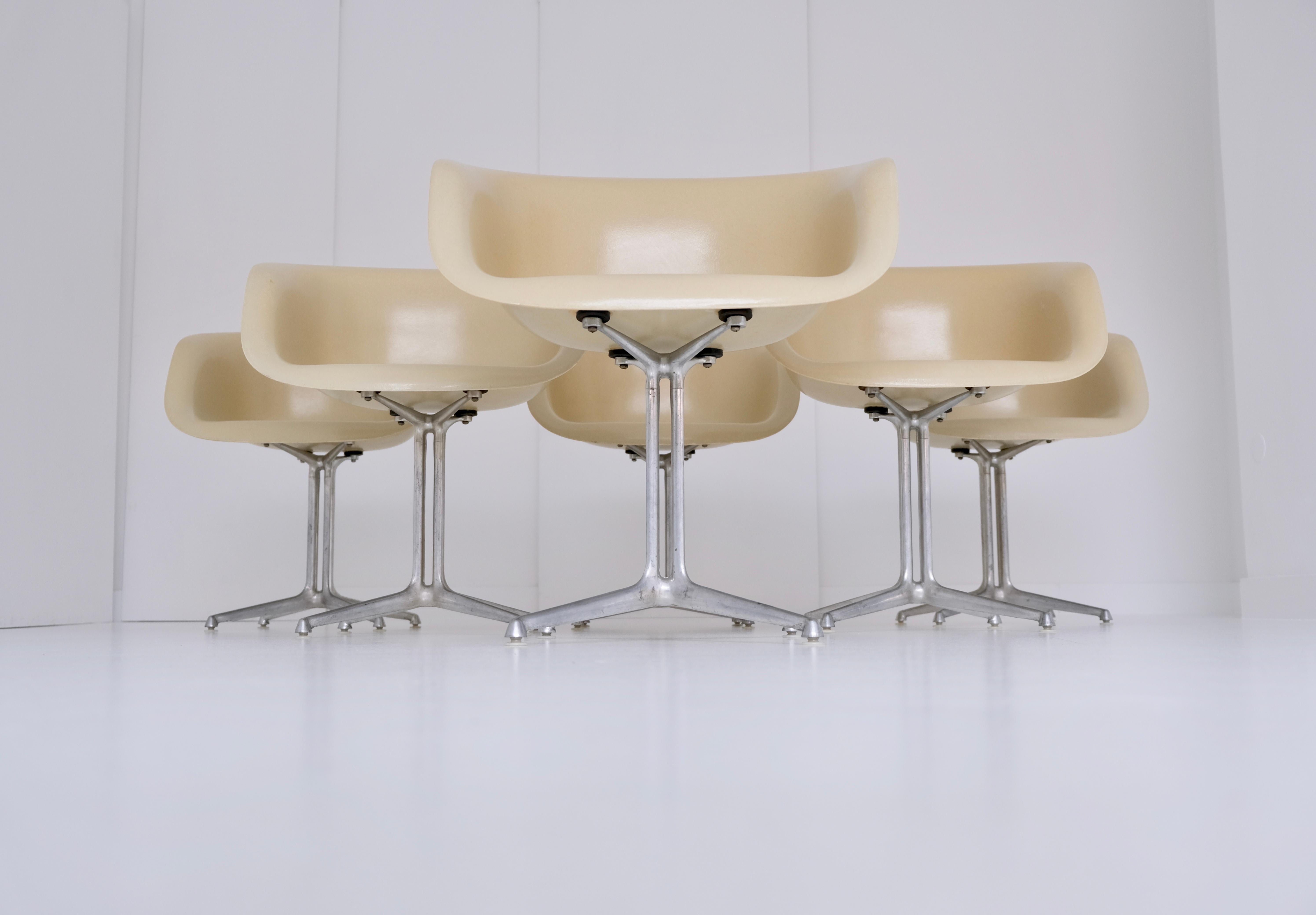 A set of six dining height armchairs (dal, model 1730-1) with parchment colored fiberglass shell seats and solid cast aluminum four-star pedestal base in ‘la fonda’ design.

Designed 1960 by Ray and Charles Eames, manufactured by Herman Miller for