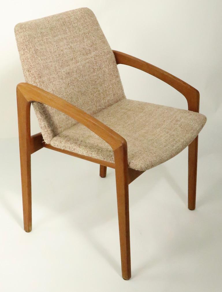 Set of 6 Danish modern dining chairs, each having a continuous arm and leg of solid teak, and upholstered seat and backs. These chairs were designed by Henning Kjaernulf for Korup Stolefabrik, Made in Denmark. All are in very fine, original