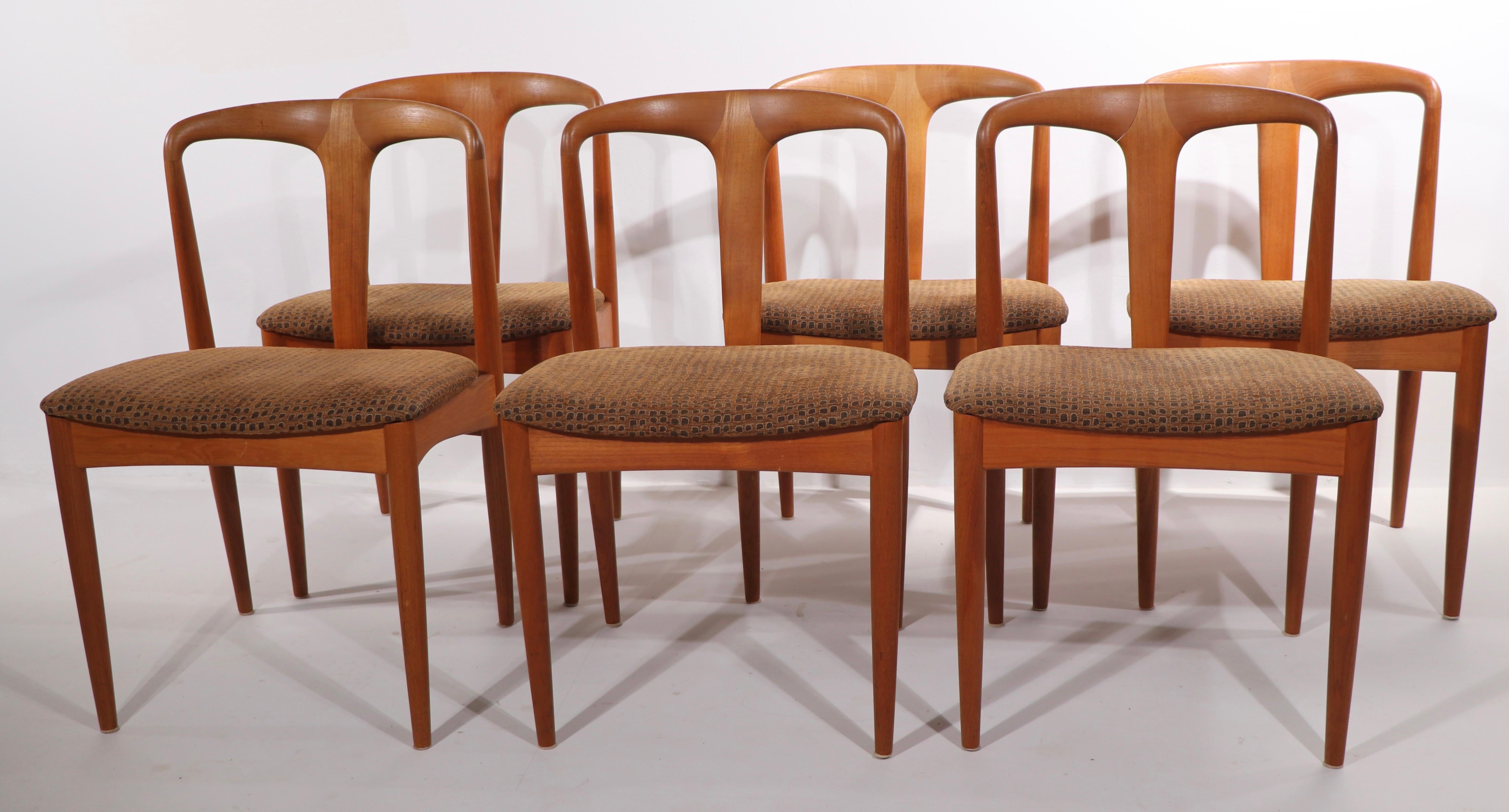 Chic set of six Danish modern dining chairs designed by Johannes Andersen made by Uldum Møbelfabrik, circa 1960's. These stylish chairs are executed in solid teak, with original upholstered seats. All are in very good, original condition, clean and
