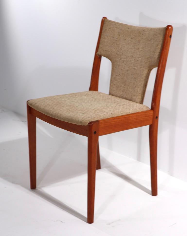 Stylish architectural set of six Danish dining chairs in teak, with unusual T form upholstered back. This set is in original, clean condition, ready to enjoy and use.