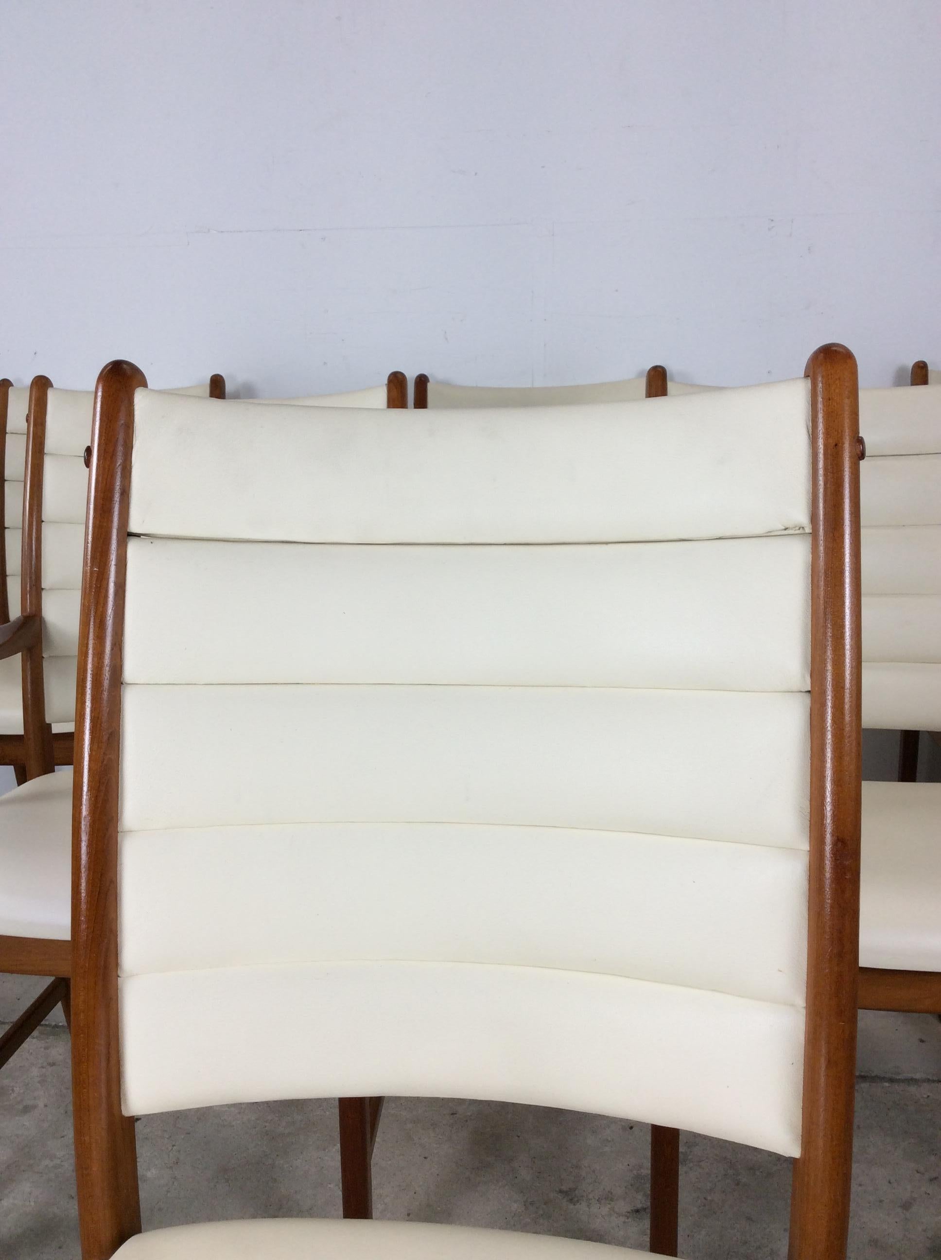 Cet ensemble de chaises de salle à manger modernes danoises présente une construction en teck massif, un revêtement en cuir blanc vintage, quatre chaises d'appoint et deux chaises à accoudoir. u2028u2028La table à manger assortie est disponible