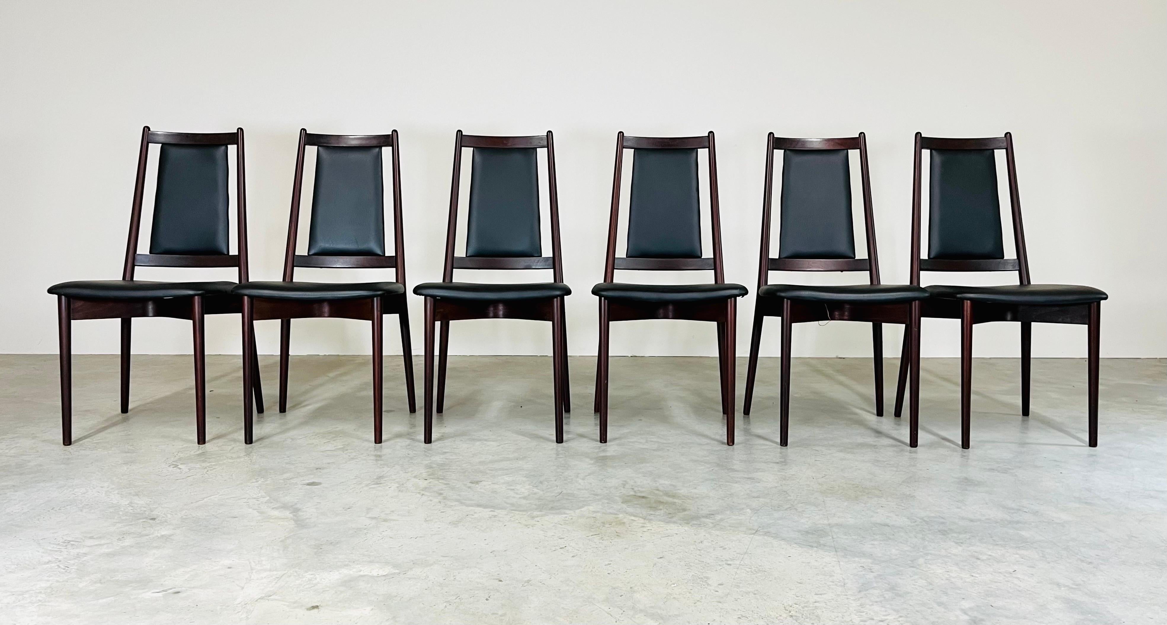 Set of six elegant Danish teak dining chairs. Teak frames and black vinyl upholstered seats and backs having a unique bentwood X-frame underneath of each seat for additional support. All are solid and in very good condition. 2 minor marks to the