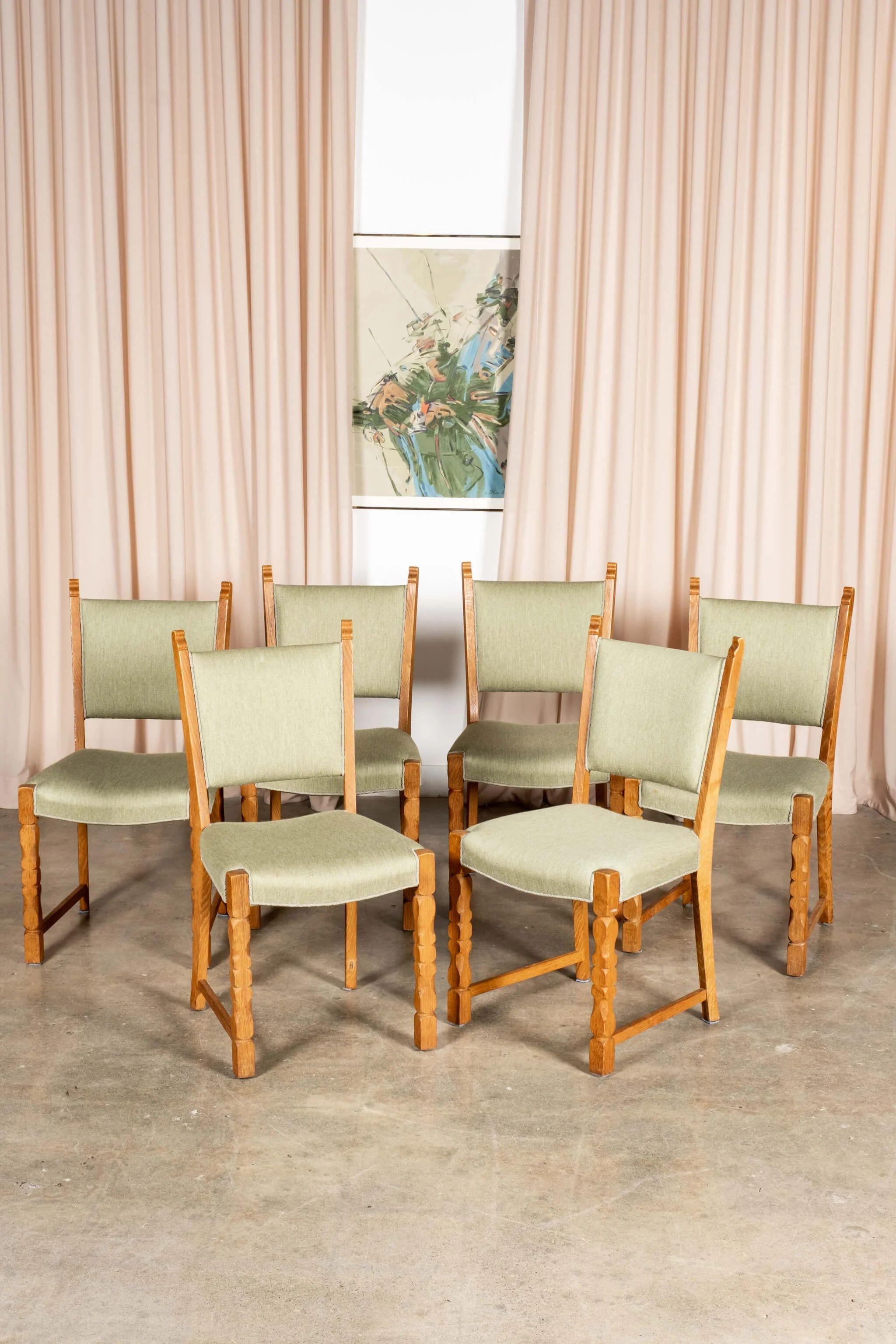 The set of 6 Danish chairs boast carved oak legs and the palest mint green upholstered seats and backs, original to the chairs. Solid, well-built and patinated oak structure, with original upholstery in good vintage condition, consistent with age