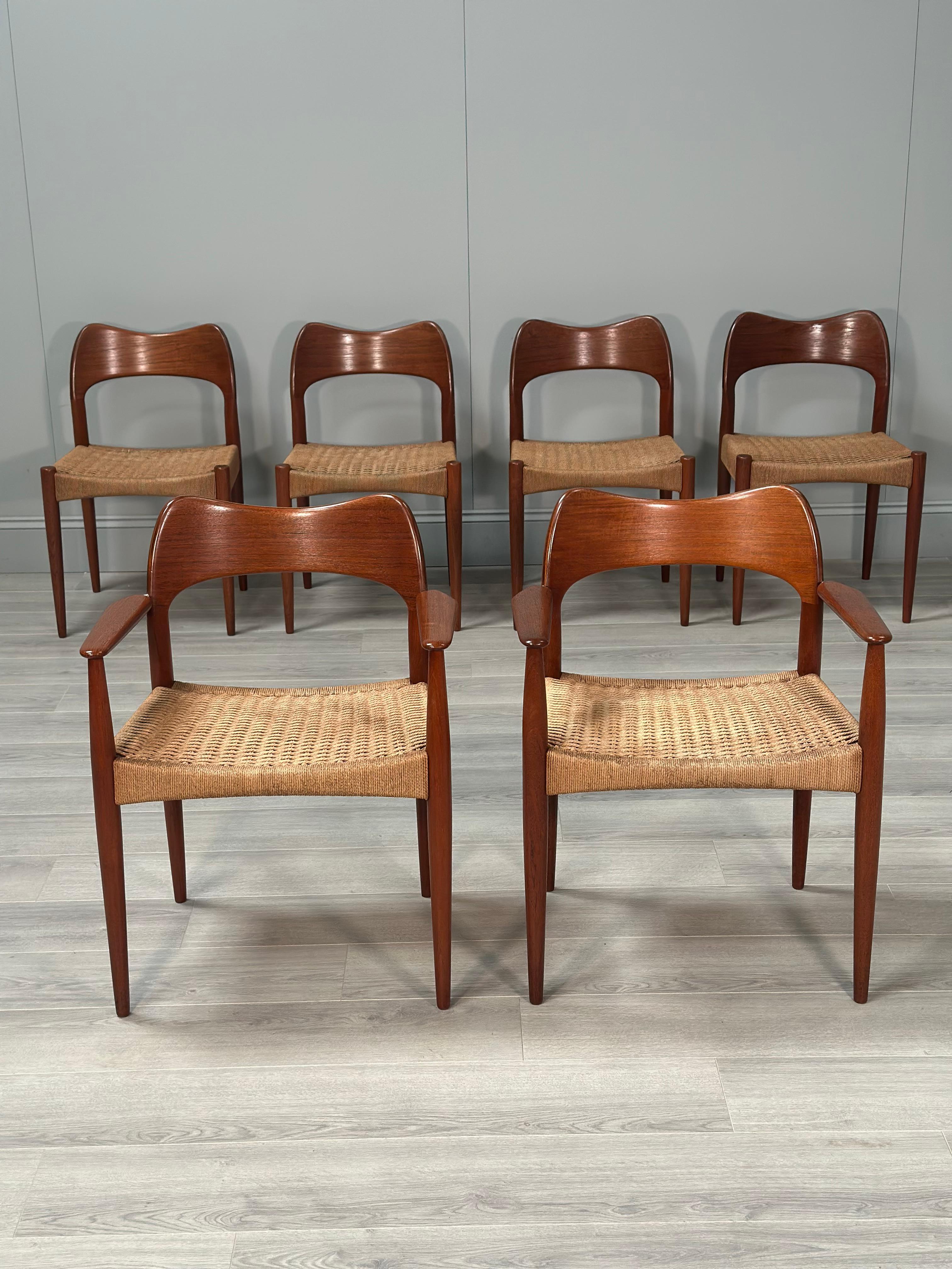 A set of six Danish teak and paper cord dining chairs designed by Arne Hovmand Olsen for Mogens Kold dating to the 1960s. This set also includes a rare pair of carver chairs rarely seen on the market. An iconic set of chairs with a curved teak back