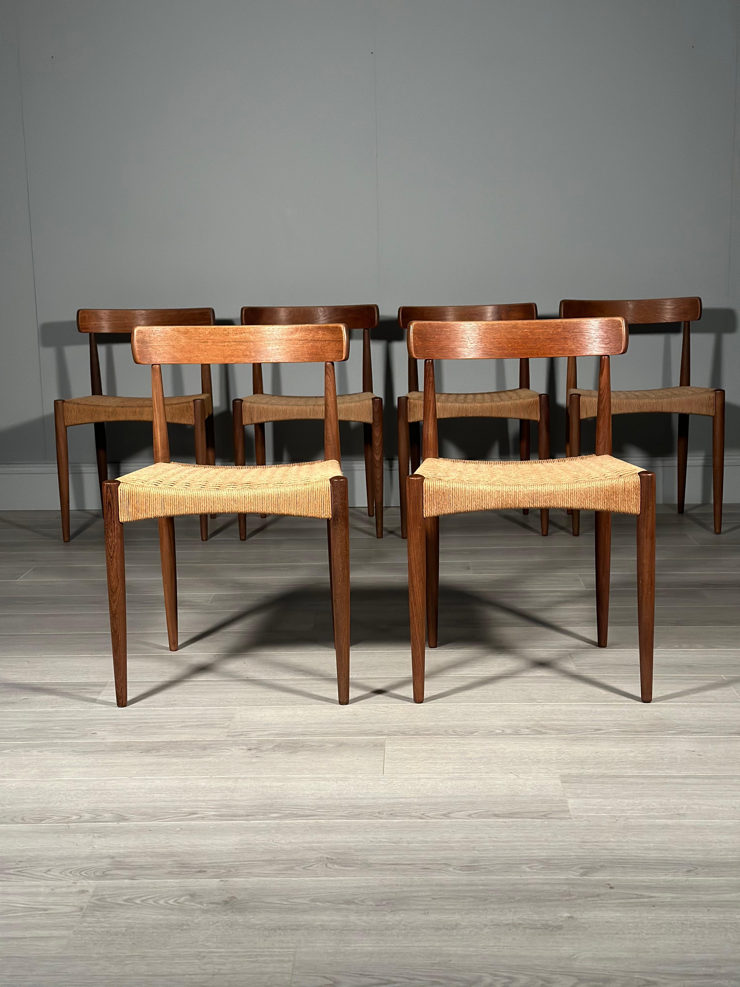 A set of six Danish teak and paper cord dining chairs designed by Arne Hovmand Olsen for Mogens Kold dating to the 1960s. An iconic set of chairs with a curved teak back and original paper cord seats, all of which are in very good original condition