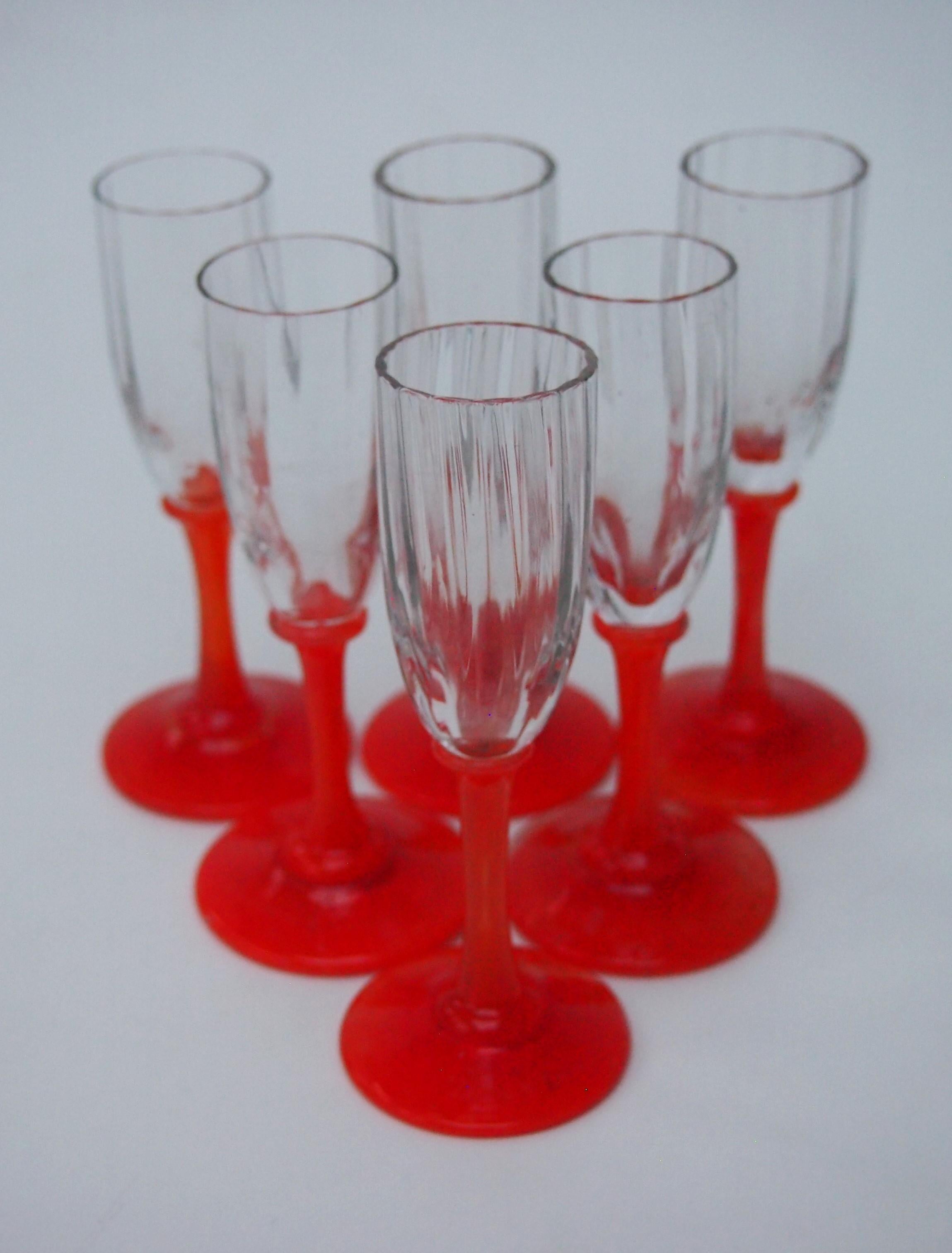 Striking set of six tiny  Daum Frères Liquor glasses. Each has a heavily ribbed clear narrow bowl with a vibrant orange stem and foot standing barely 4 inches tall -All of them are finely signed Daum France on the top of the foot - see picture 3.