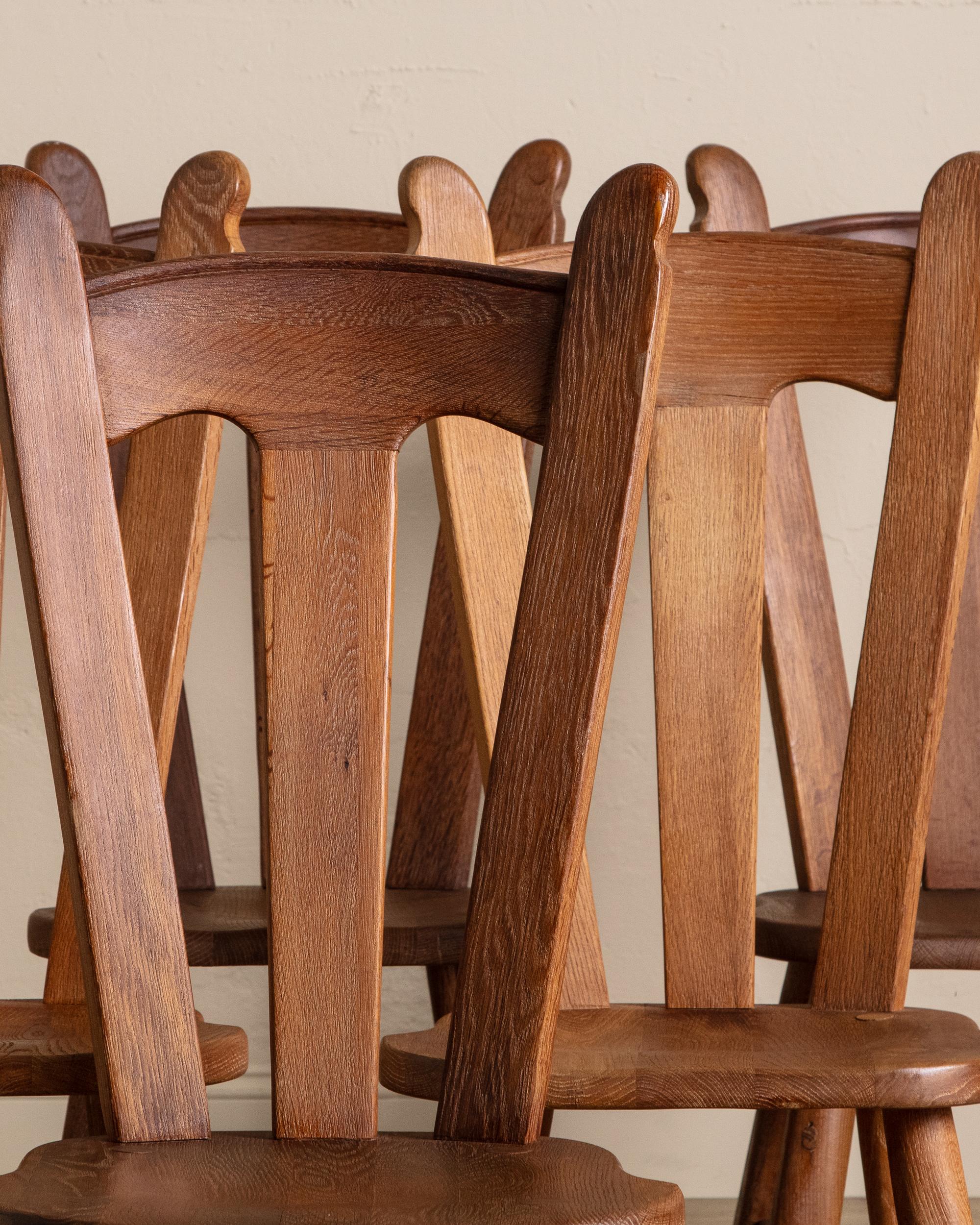 Questo set di sei sedie da pranzo vintage è uno studio di artigianato senza tempo e di raffinata rusticità. Realizzata a mano in legno massiccio, ogni sedia mostra una patina splendidamente invecchiata che accentua la ricchezza delle sue venature