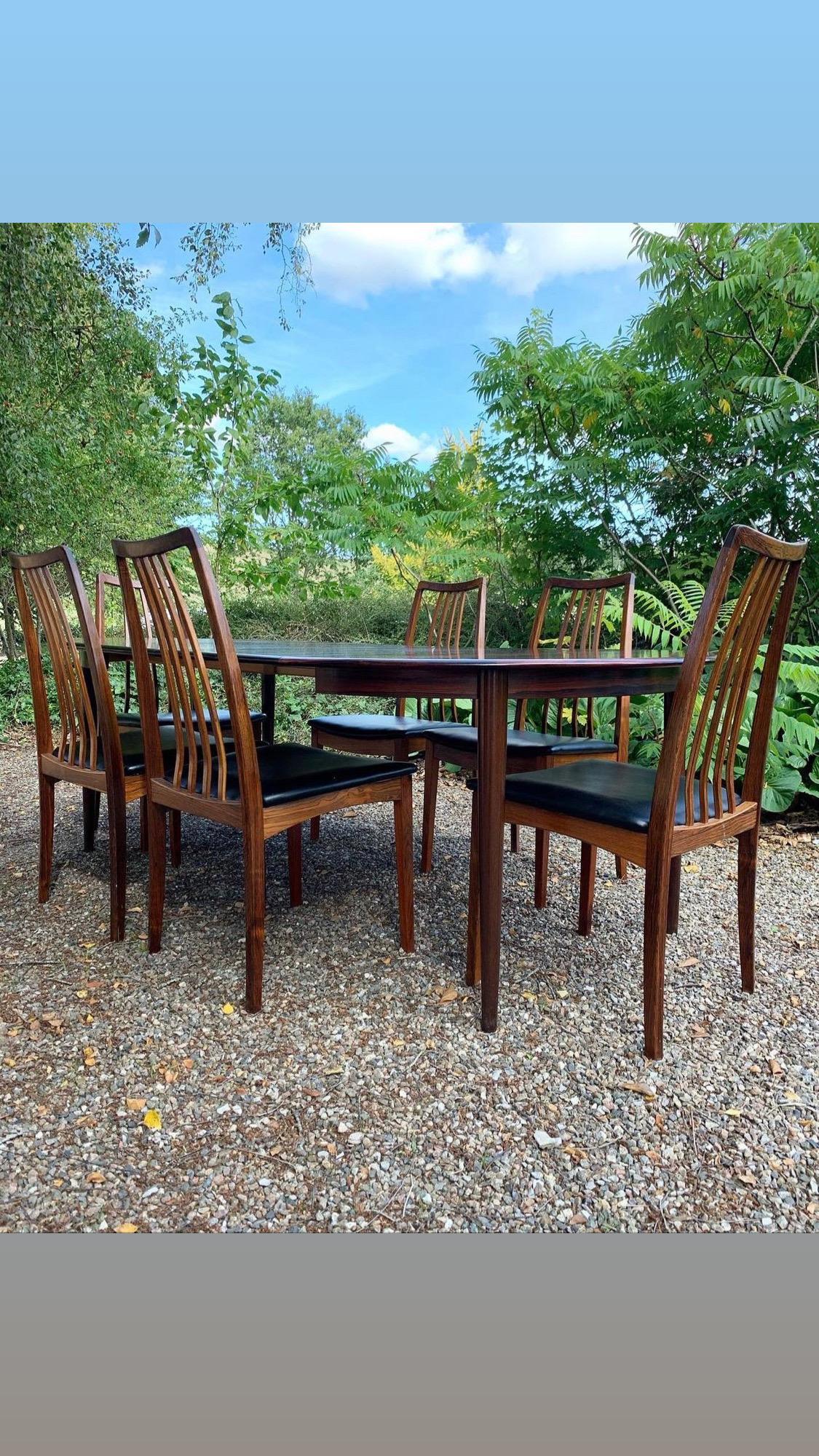 Set including a dining table in rosewood with 2 leaves, produced by Skovmand & Andersen in Denmark in 1960s and 6 dining chairs also in rosewood, new upholstered with leatherette/faux leather. 

The set is in a good condition. One chair has a