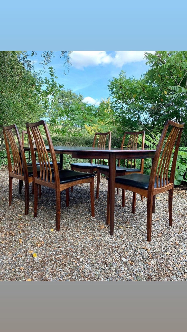 Set including a dining table in rosewood with 2 leaves, produced by Skovmand & Andersen in Denmark in 1960s and 6 dining chairs also in rosewood, new upholstered with leatherette/faux leather. 

The set is in a good condition. One chair has a