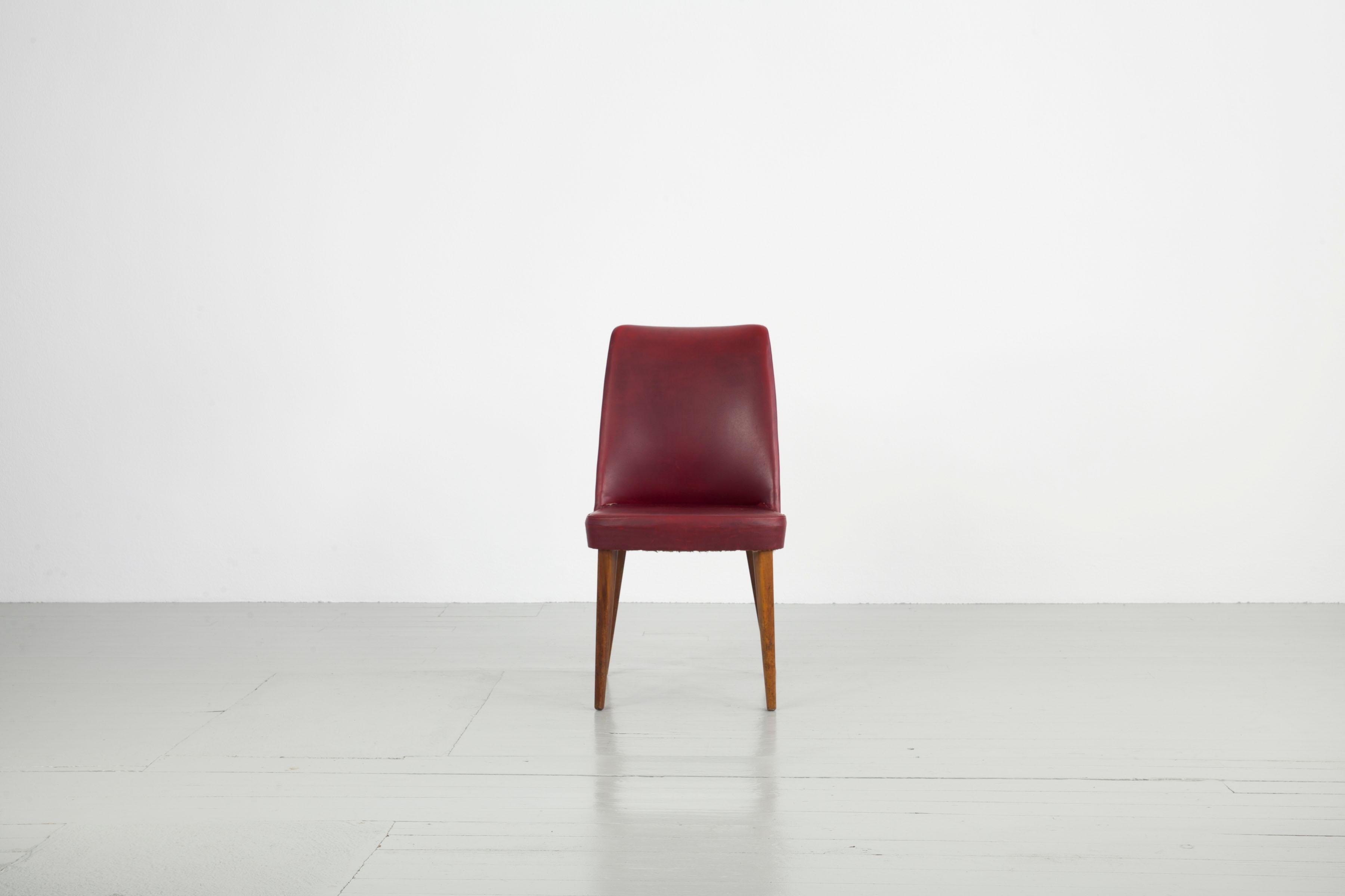 Dieses Set aus sechs Stühlen wurde in den 1950er Jahren von Anonima Castelli in Italien hergestellt. Die konisch geformten Stuhlbeine sind aus Eichenholz gefertigt, die Sitzfläche ist mit rotem Kunstleder bezogen. Die Stühle müssen neu gepolstert