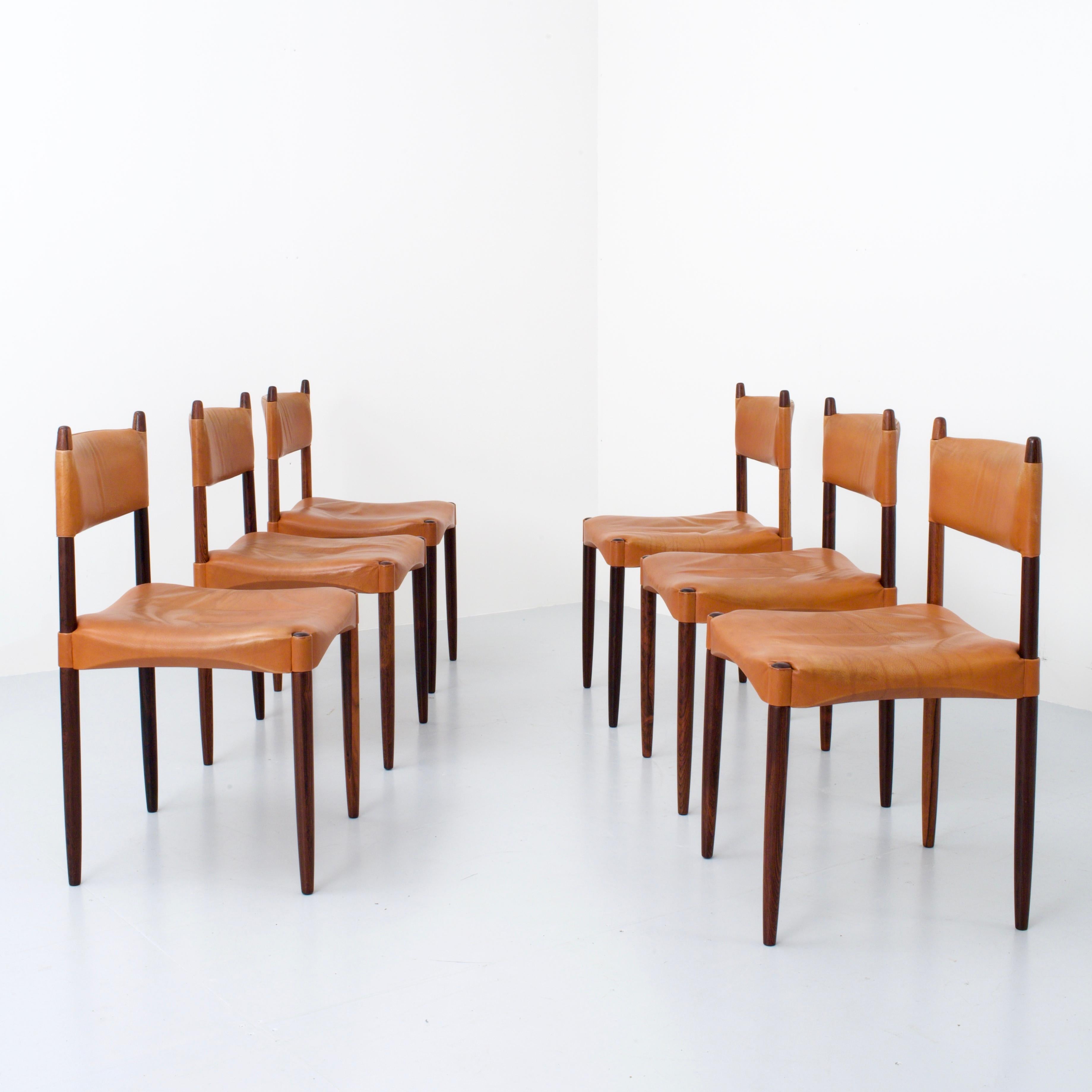 This beautifully detailed set of chairs by Anders Jensen for Holstebro Møbelfabrik features a luminous dark Brazilian rosewood frame and patinated cognac-coloured leather used for the seating and the back rest. Very outspoken flames in the rosewood