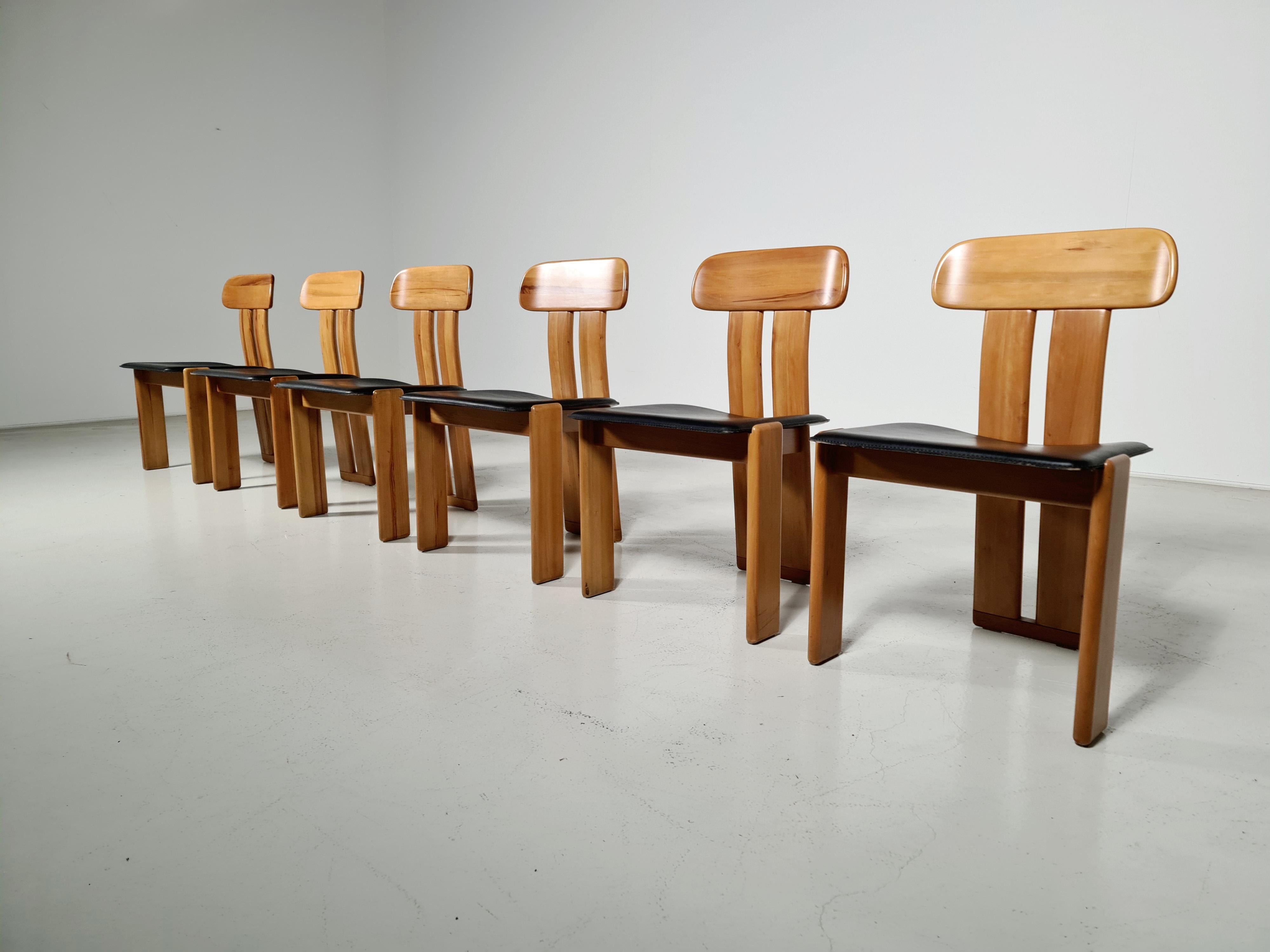 Set of 6 sculptural Italian dining chairs with saddle-stitched leather seats, black colored. Very comfortable even for larger sitters despite the slim profile. The color of the Italian walnut frame is warm which accompanies the patinated black