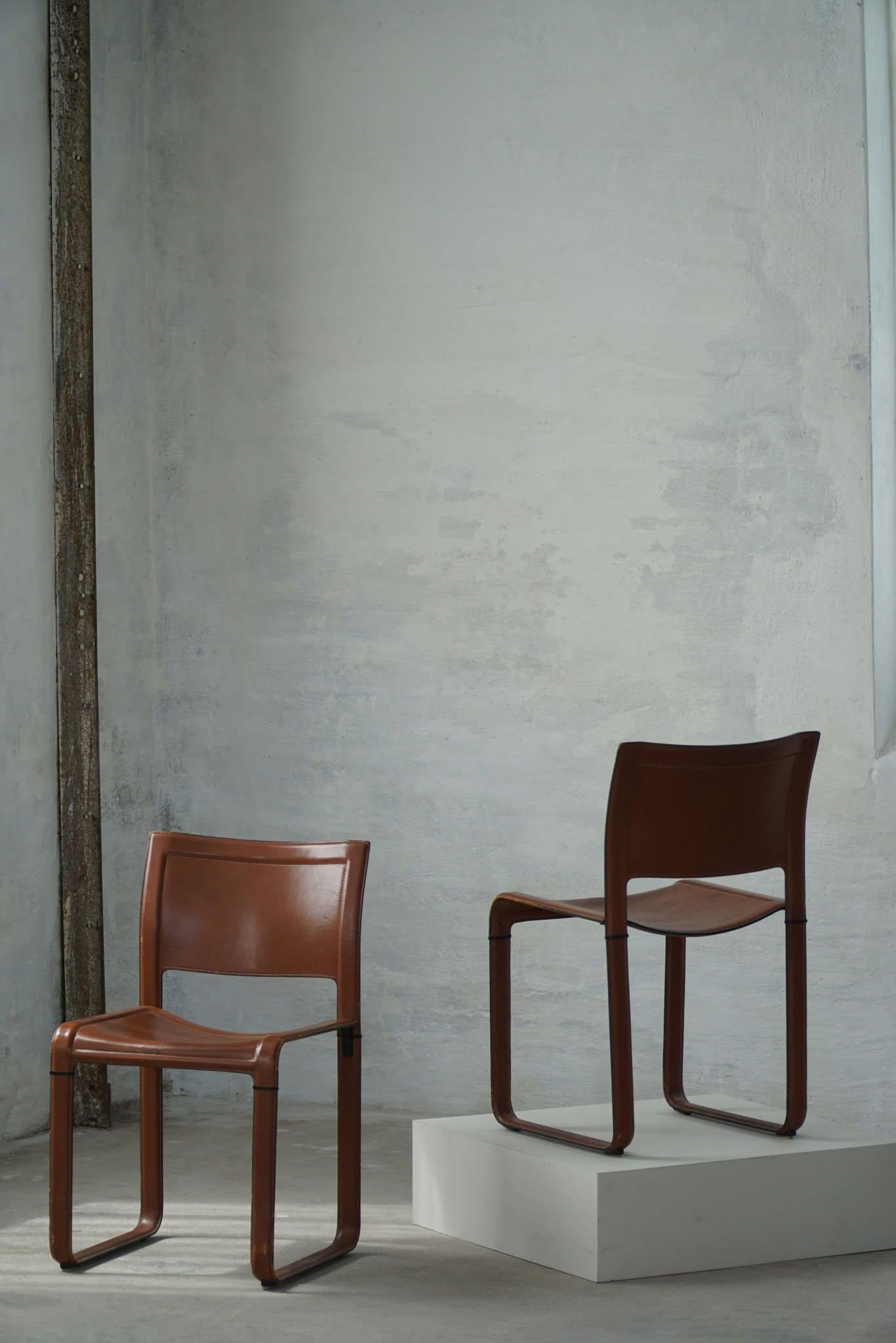 Set di sei sedie da pranzo italiane disegnate da Tito Agnoli per Matteo Grassi, Italia, anni Settanta. Queste eleganti sedie da pranzo sono completamente rivestite in ricca pelle rosso-marrone, compresa la seduta, lo schienale e le gambe, creando