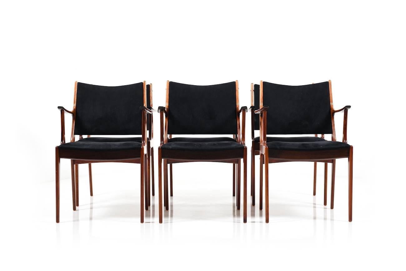 Midcentury Danish rosewood dining chairs by Johannes Andersen for Uldum Møbelfabrik. Model UM85. Seats upholstery in black fabric. Late 1960s. Set of six chairs.
  