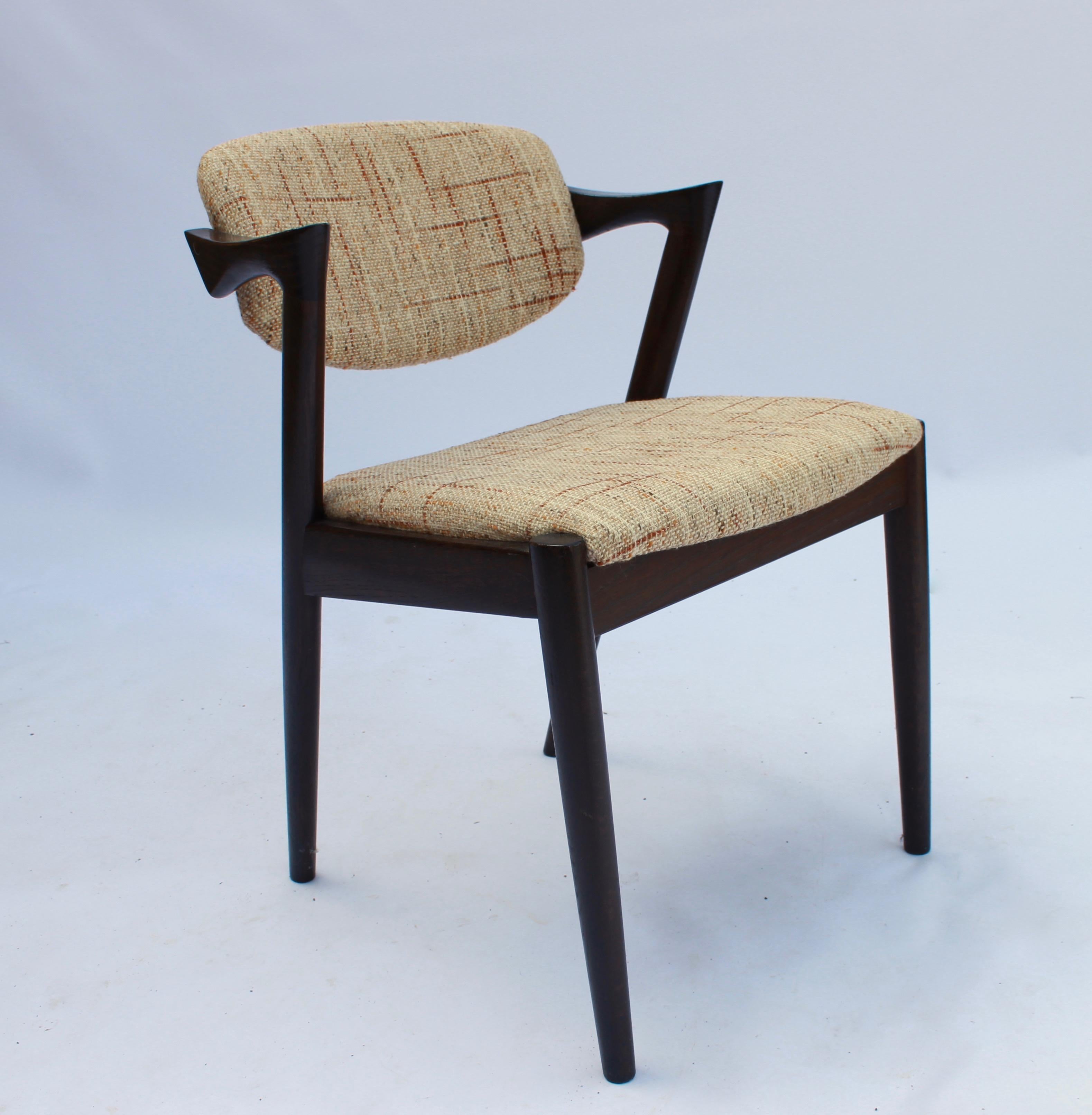 A set of 6 dining chairs, model 42, designed by Kai Kristiansen and manufactured by Schou Andersen in the 1960s. The chairs are of dark oak and upholstered in light wool fabric.