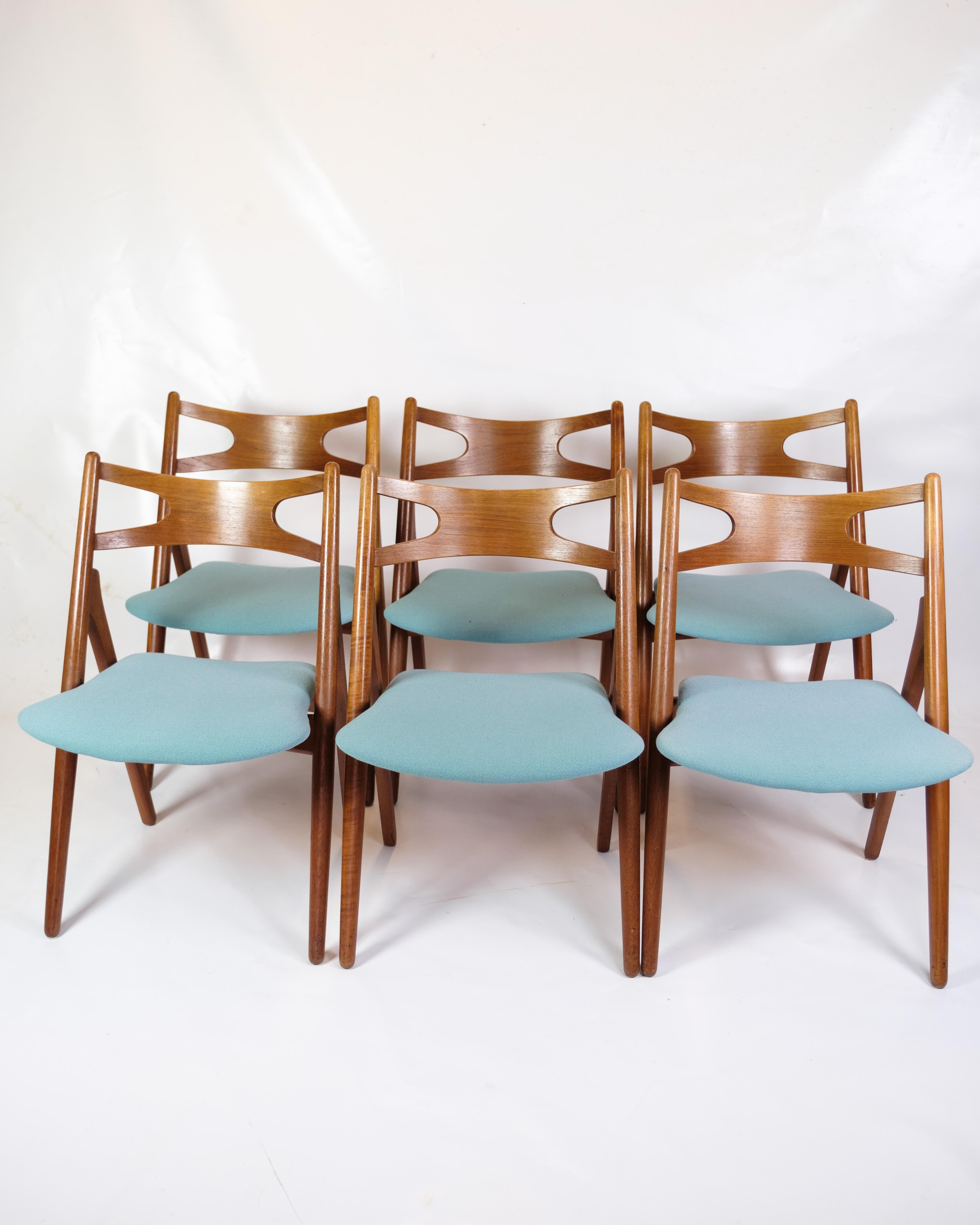 Questo set di sei sedie per sala da pranzo, modello CH29P, è realizzato in legno di teak e ha un'eleganza senza tempo che si adatta perfettamente a qualsiasi zona pranzo. Le sedie sono rivestite con cura in un tessuto azzurro che crea un piacevole