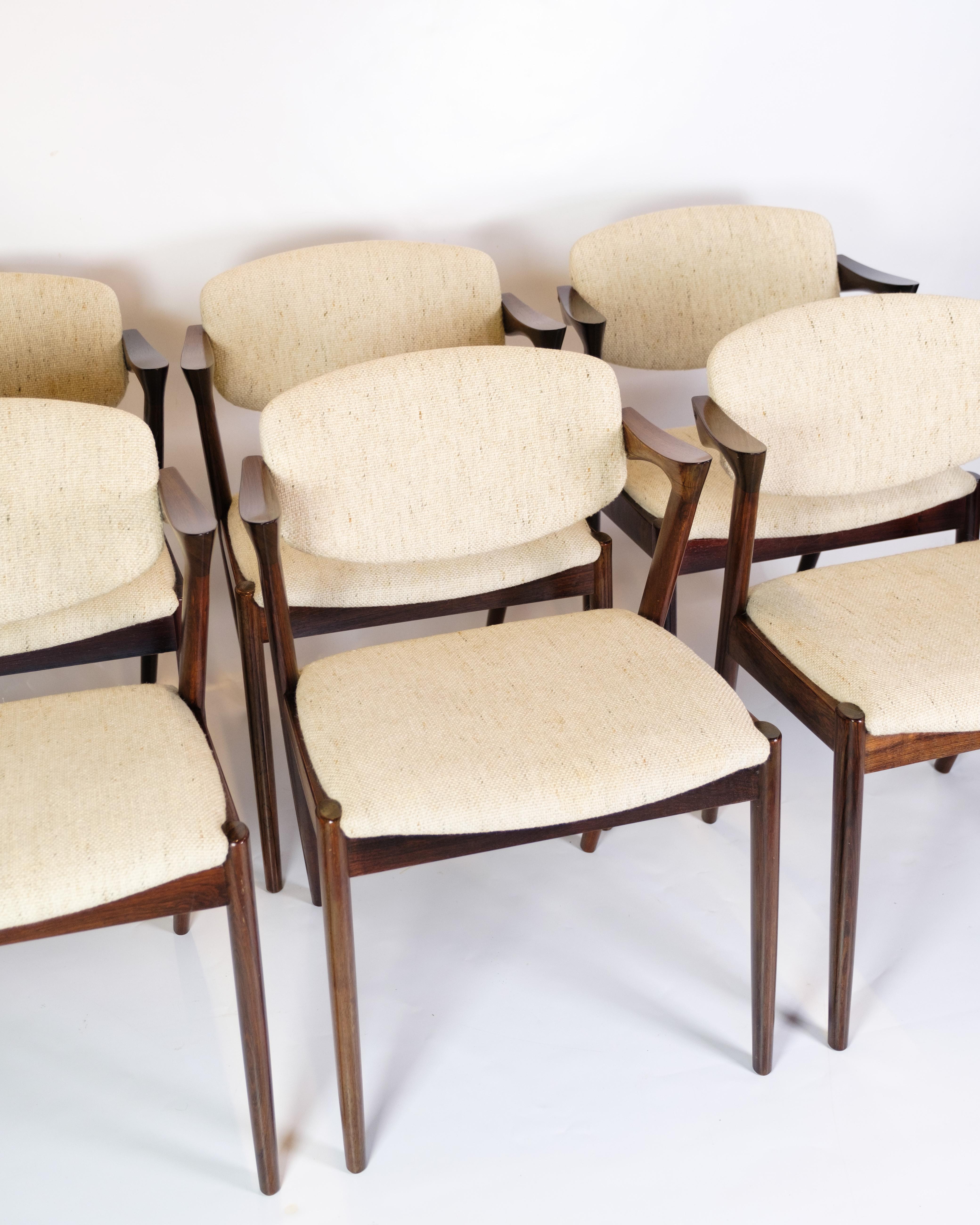 Set of 6 dining table chairs, model 42, made of rosewood, designed by Kai Kristiansen and produced by Schou Andersen in the 1960s. The chairs have light fabric cushions that add comfort and a beautiful contrast to the dark tone of the rosewood. They