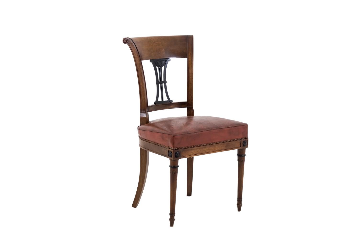 Set of 6 Directoire style chairs in mahogany, standing on two saber-shaped rear legs and two front round and tapered legs: front tapered legs with rings and topped by joints decorated with darkened rosette. Moulded straight apron. Back top rail