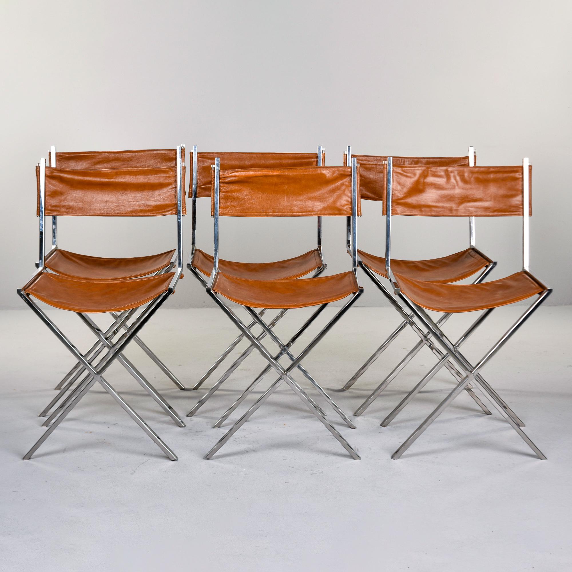 Encontrado en Francia, este conjunto de seis sillas de cromo y cuero estilo director data de los años setenta. Las estructuras cromadas tienen una base en forma de X con asientos y respaldos de cuero color silla de montar. Los bastidores son de