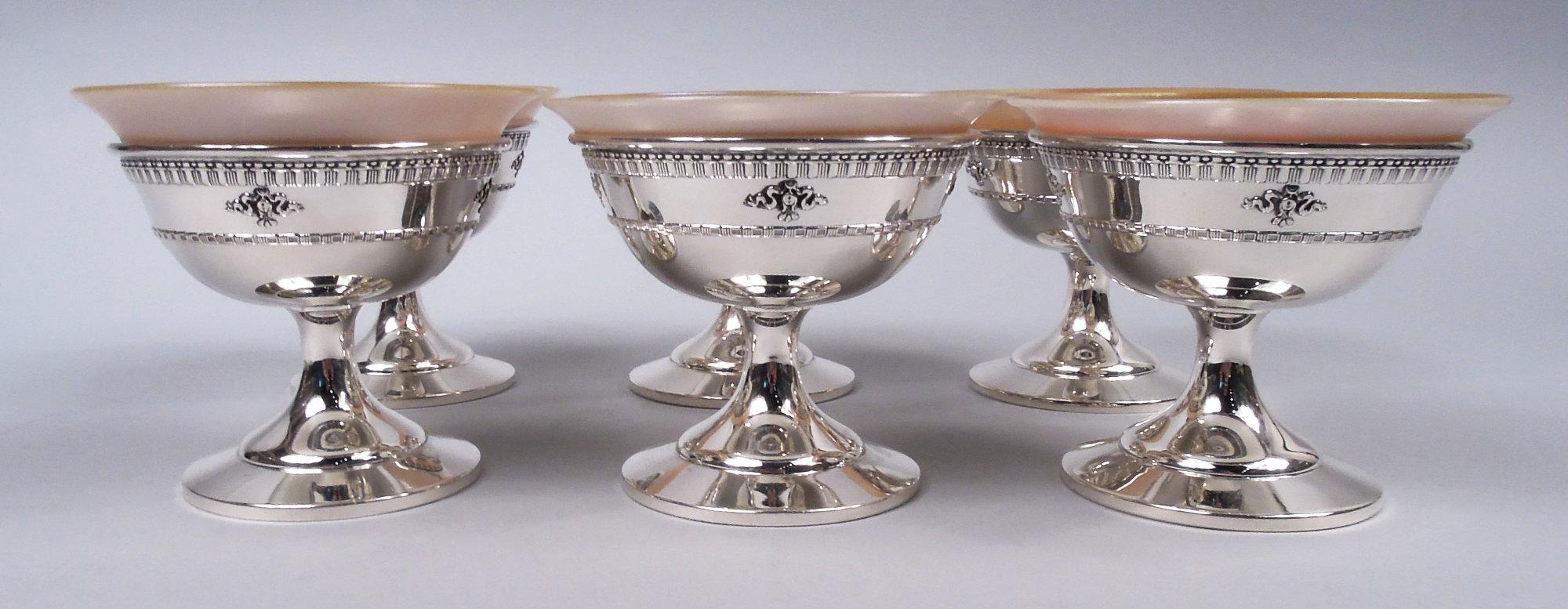 Set of 6 Windsor sterling silver dessert cups. Made by Dominick & Haff in New York, ca 1920. Each: Curved bowl on spread support mounted to raised foot. Embossed ornament with ribbon-tied pendant flowers between Classical borders. Fully marked