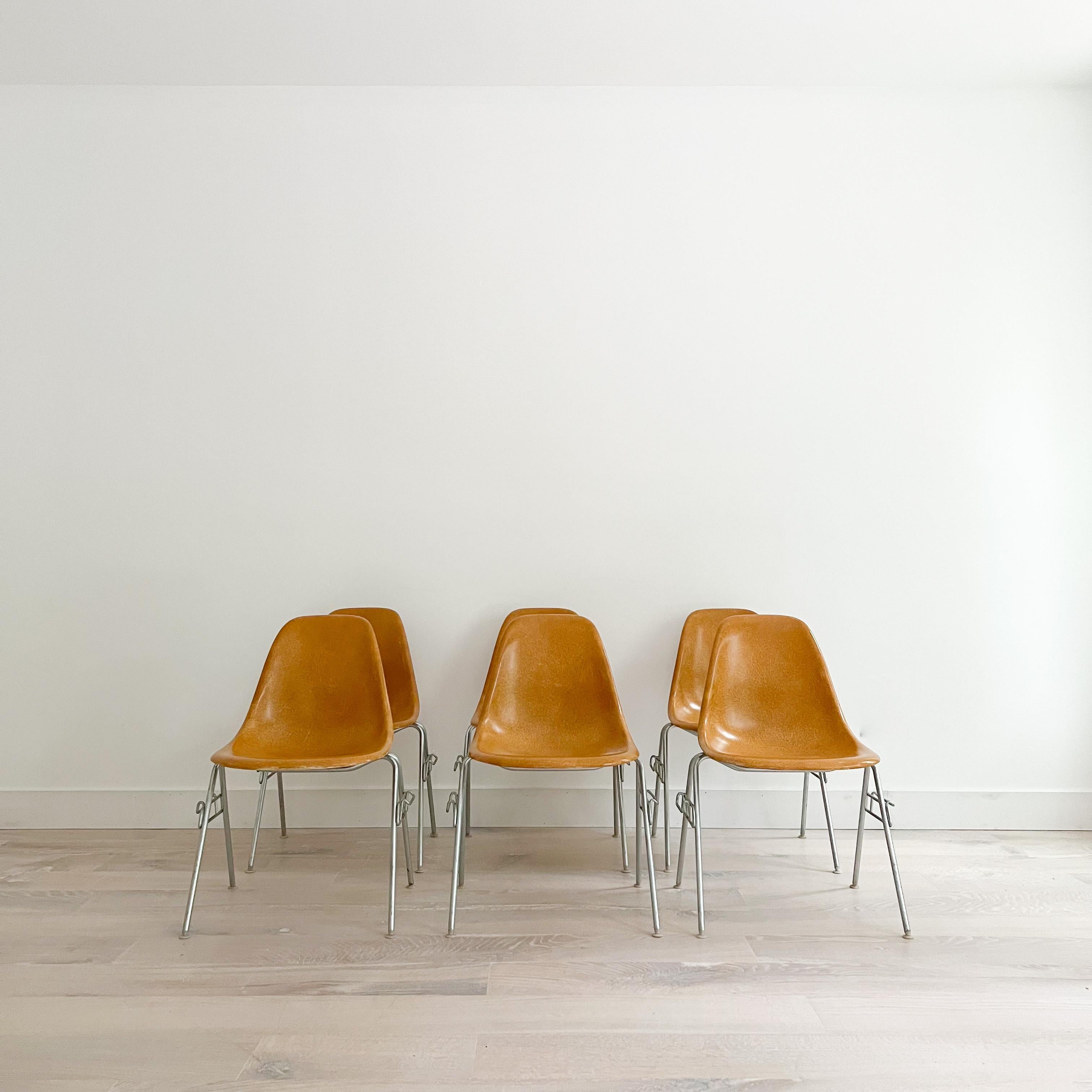 Set of 6 original 1960s molded fiberglass light ochre shell chairs on stacking base, designed by Charles and Ray Eames for Herman Miller. Gleaming shells are in original condition, each with a distinct thready texture. Shown here mounted on