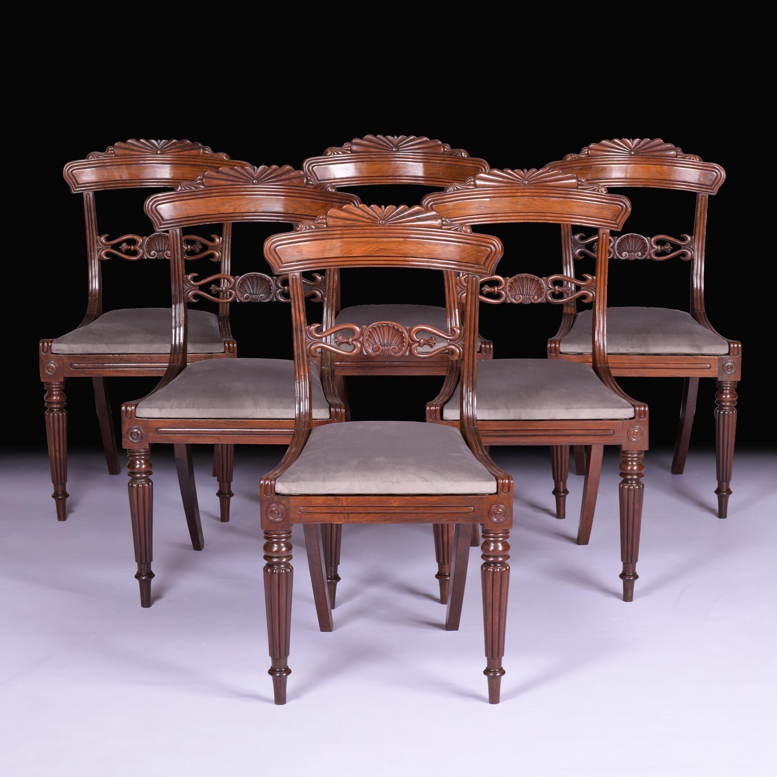 A very fine set of 6 Regency dining chairs attributed to Gillows of Lancaster and London, having a quality figured top rail with a reeded edge and carved top supported by shaped reeded supports over foliate scrolled splats, drop-in seats with luxury