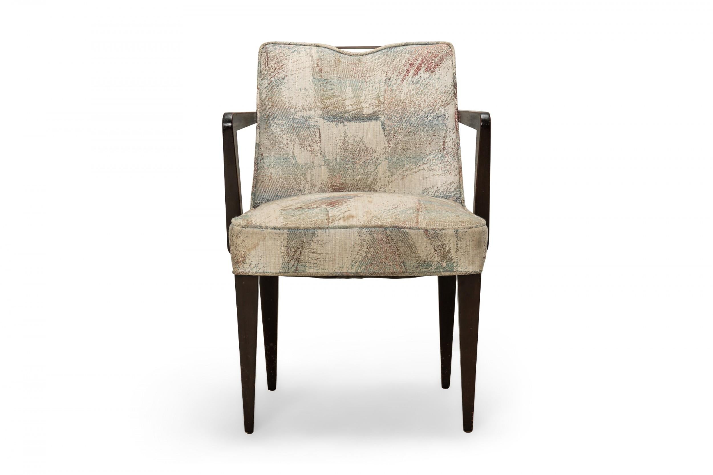 Set of 6 American mid-century dining chairs (2 arms and 4 sides) with square backs featuring a brass central handle, patterned gray and pastel colored seat and back cushions, resting on four square tapered walnut legs. (EDWARD J WORMLEY FOR DUNBAR