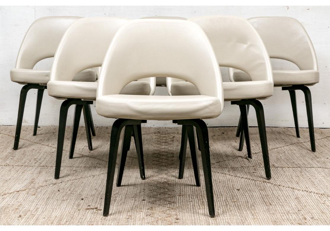 Classic Mid Century design from 1950 designed by iconic Finnish American designer Eero Saarinen. Knoll 72CW open-backed chairs, armless, with fixed position, resting on ebonized wood legs in faceted and tapering form. The chairs upholstered in ecru