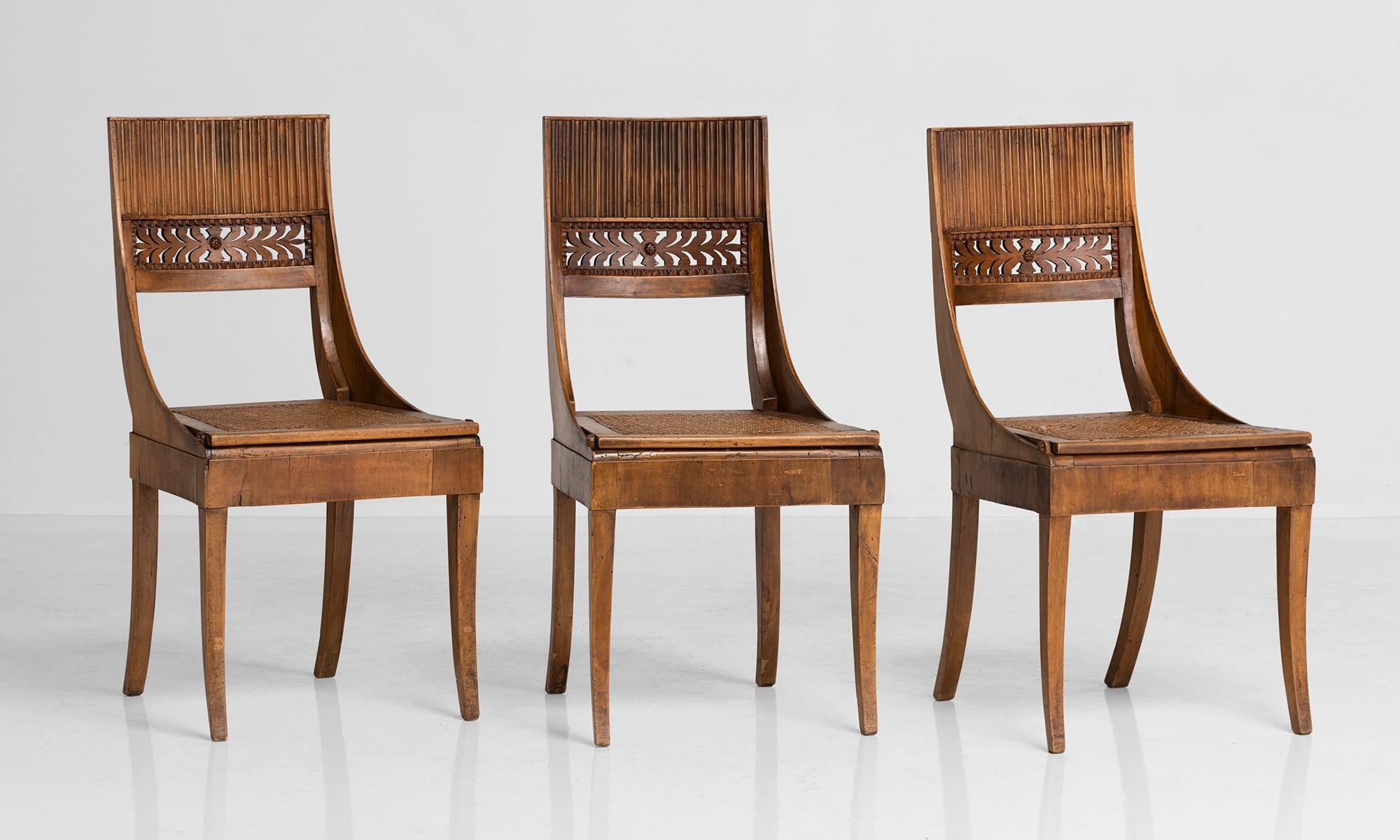 Fruitwood dining chairs with hand carved details and woven cane seat.