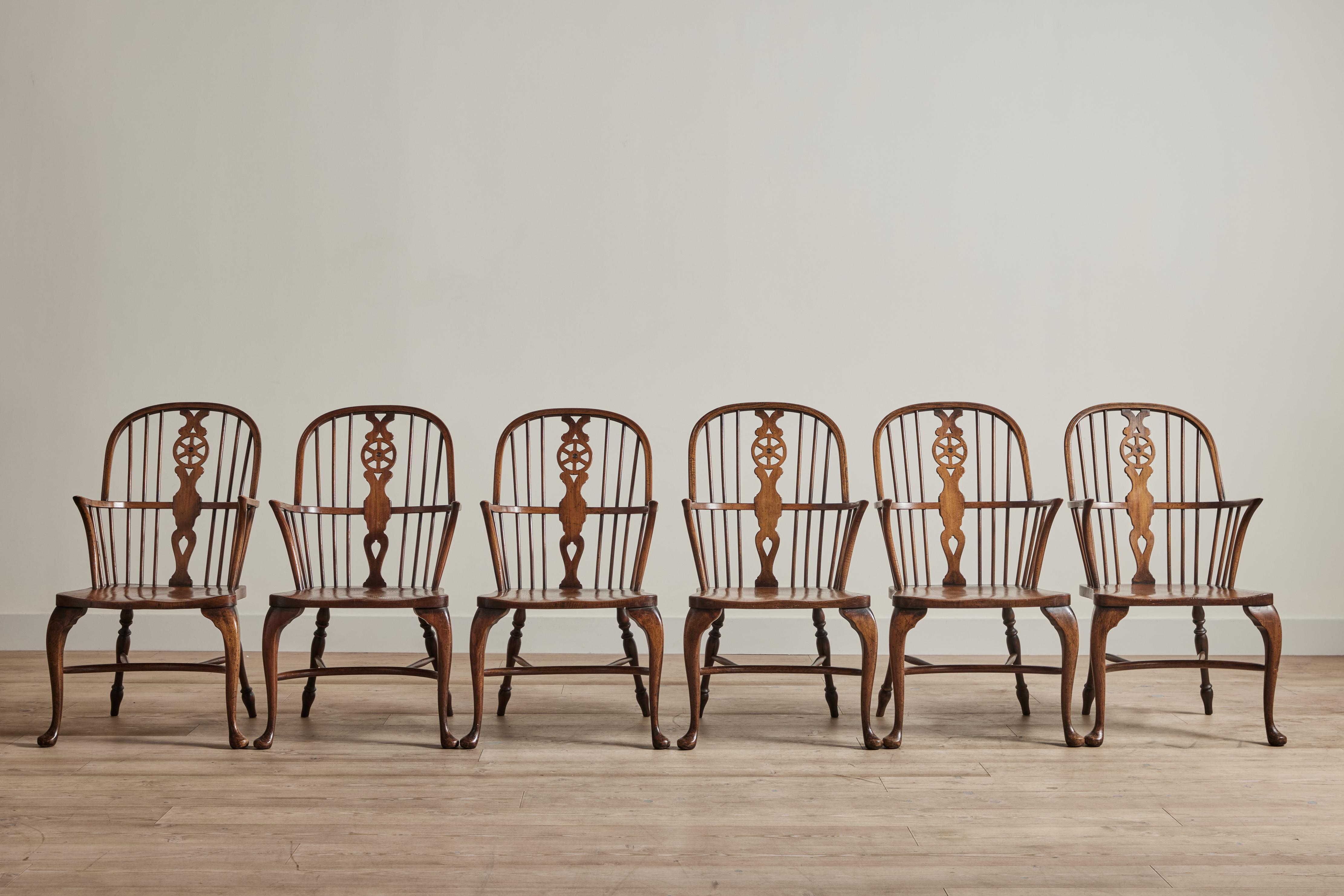 Set of six elmwood Georgian style windsor chairs from England circa 1960. Some wear on wood is consistent with age and use.