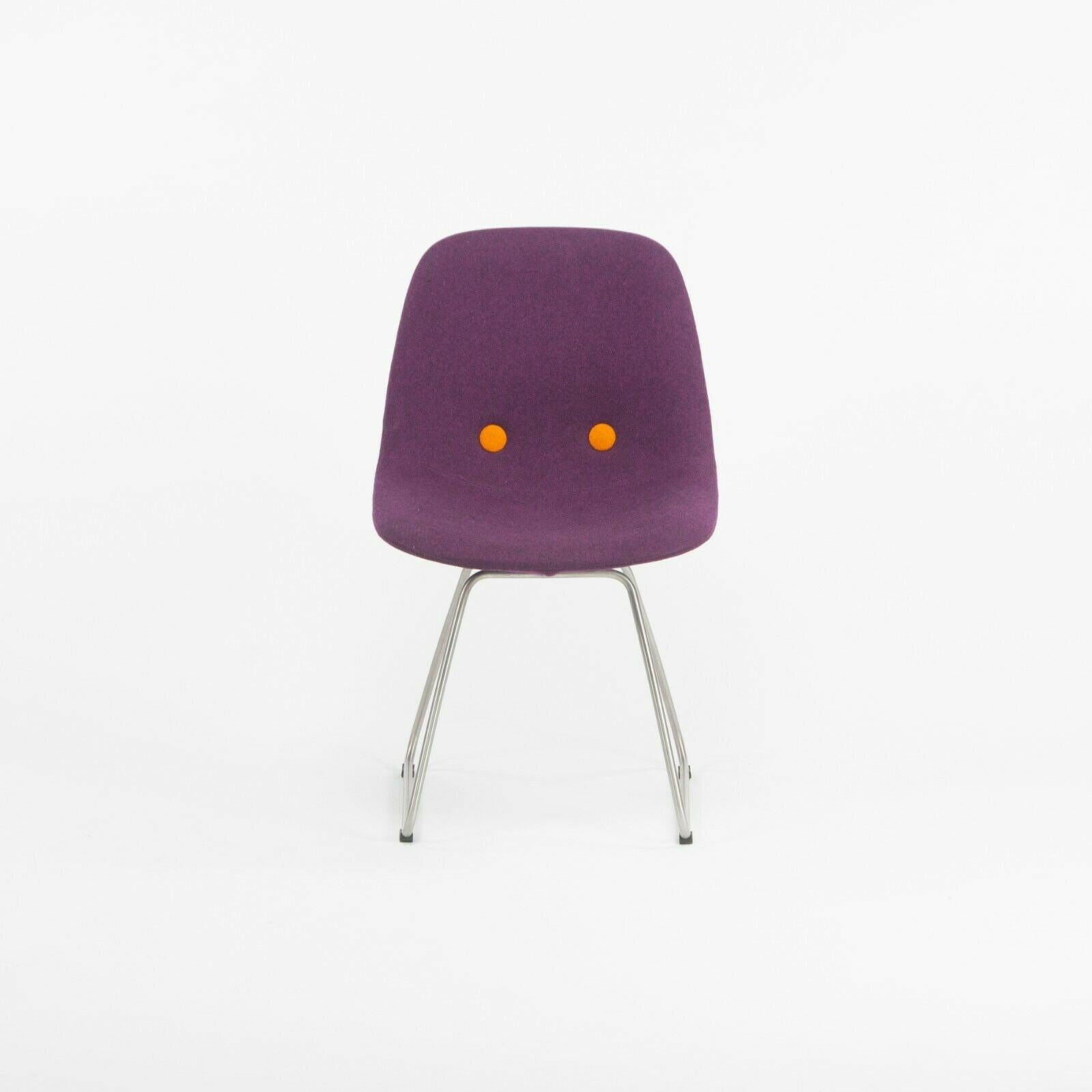 Nous proposons à la vente un ensemble de six chaises Erik Jorgensen EJ 2 Eyes Chair de Foersom + Hiort-Lorenzen. Ces chaises sont magnifiquement revêtues d'un tissu de laine violet de Kvadrat avec des boutons orange contrastés. Les chaises semblent