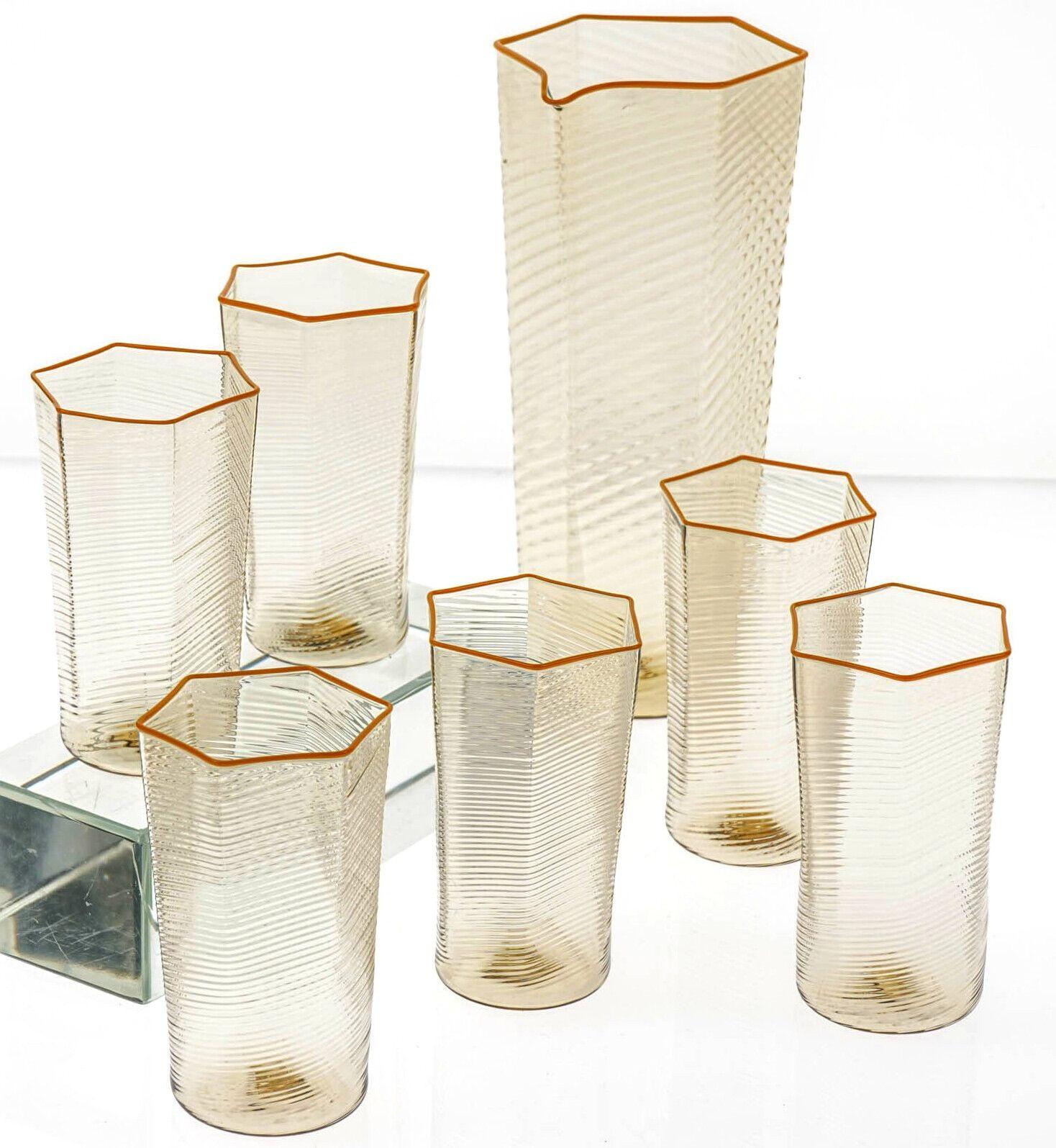 Rare and unique set of 6 handmade Murano glass and a jug in deep amber fume color.

The beauty of this set is the rigadin ritorto pattern applied to the body of the tumblers and pitcher. The fumè color ties magnificently to the Mustard Yellow toned