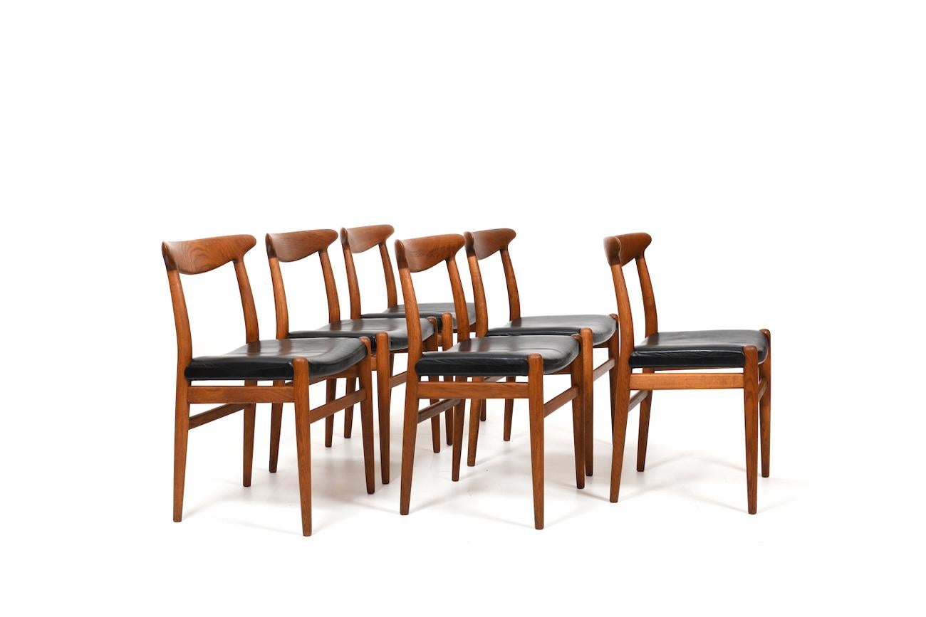 Satz von sechs alten Hans J. Wegner Stühlen aus massiver Eiche und schwarzem Leder. Modell W2. Produziert von C.M. Madsen Dänemark in den 1950er Jahren. Mit schöner Patina und im Originalzustand.