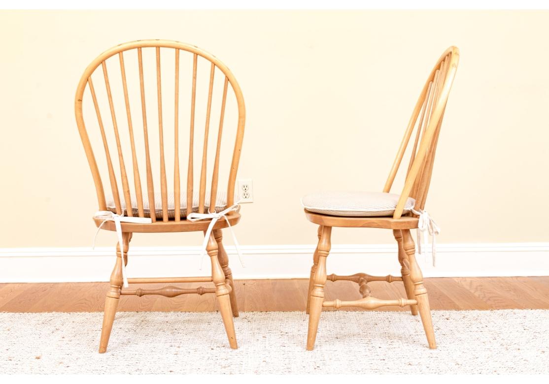 Juego de 6 sillas Windsor de madera maciza de haya y cerezo, muy bien fabricadas, con construcción de clavijas, patas y camilla torneadas y asiento de silla de montar. Los husillos cónicos del respaldo, con visibles puntas cuneiformes en contraste,