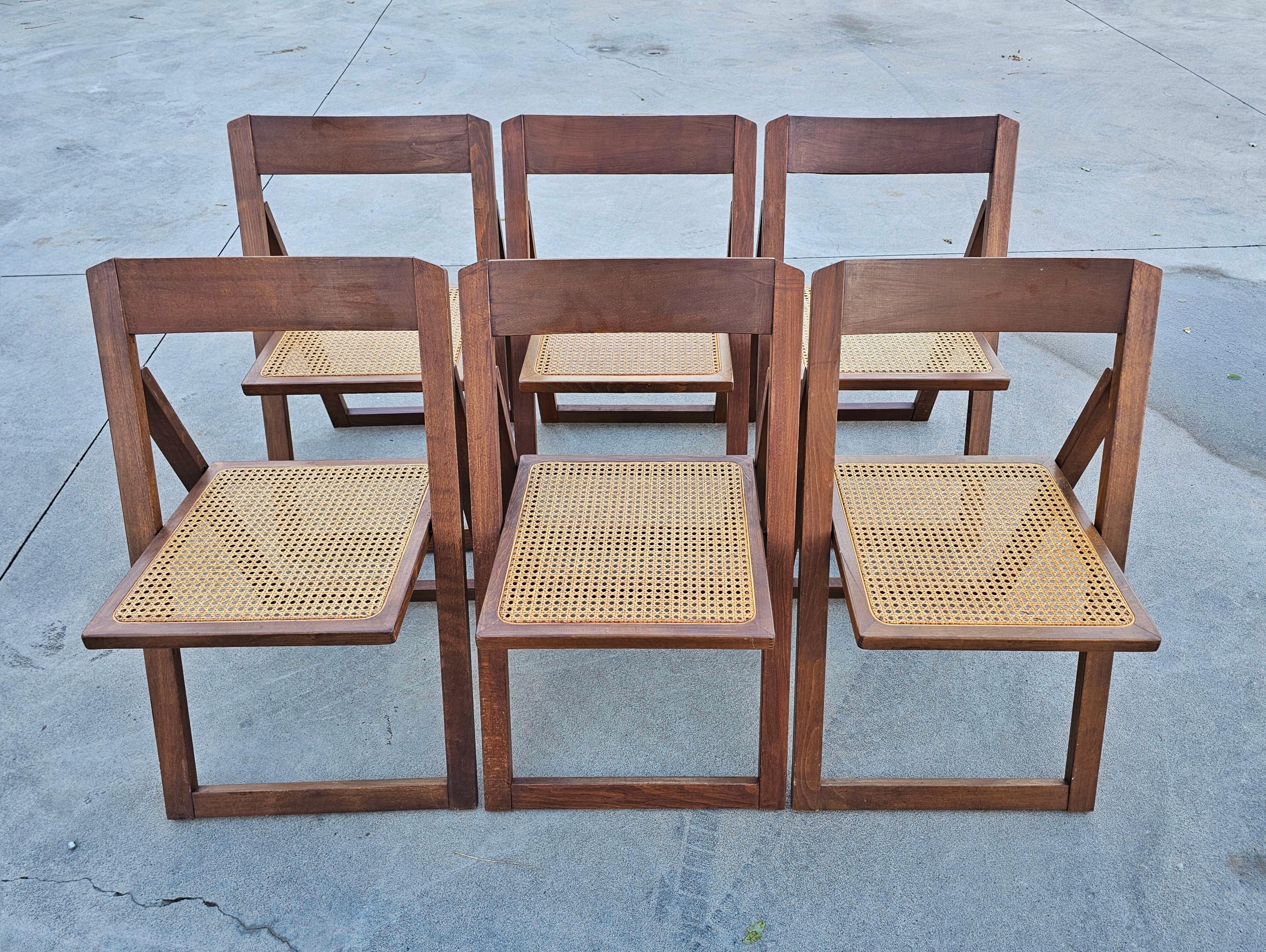 This listing features a set of 6 Mid Century Modern folding chairs with cane seats designed in style of Trieste Folding Chair by Aldo Jacober for Alberto Bazzani. The chairs are made in Italy in 1980s.

Very good vintage condition with some signs of