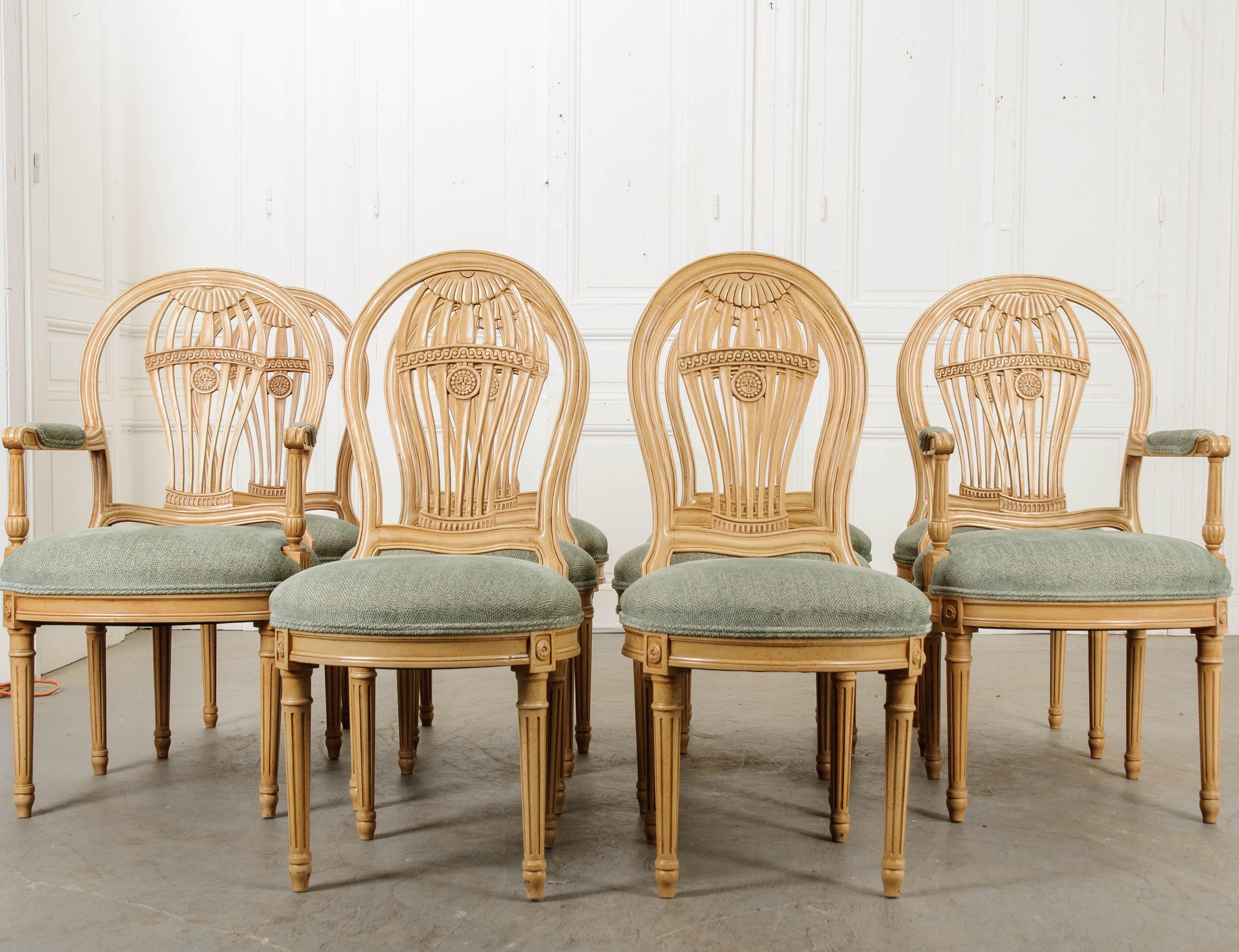 A whimsical set of upholstered French reproduction dining chairs, produced there in the 20th Century. The set contains four side chairs and two armchairs. They have painted frames that are made to appear antique. Their overall style is in accordance