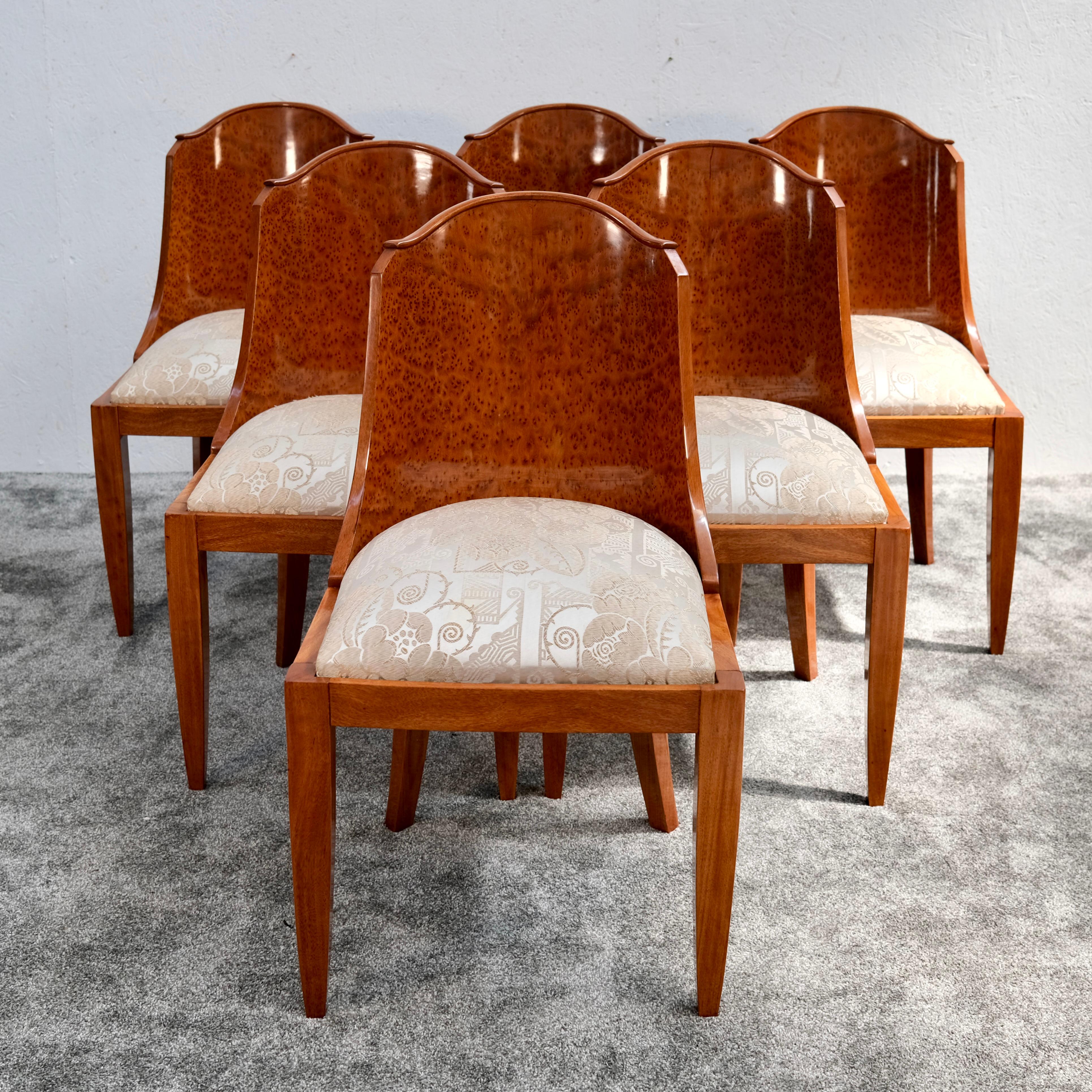 Questo raro set di sei sedie Art Deco originali della Francia degli anni '30 mette in mostra la raffinata eleganza e la maestria dell'epoca. Gli schienali dolcemente curvi sono impiallacciati in legno di Thuja lucido, con un motivo di venature