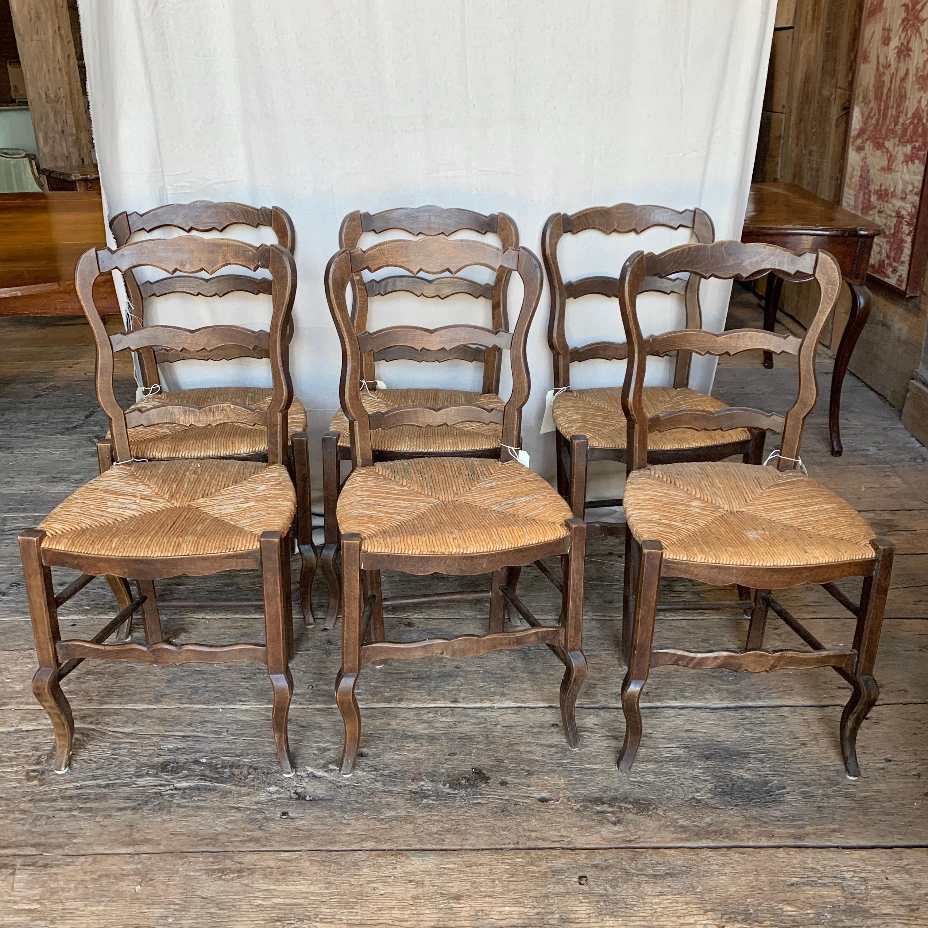 A set of 6 French Country ladder-back dining chairs in stained beech wood, with rush seats, circa 1870.