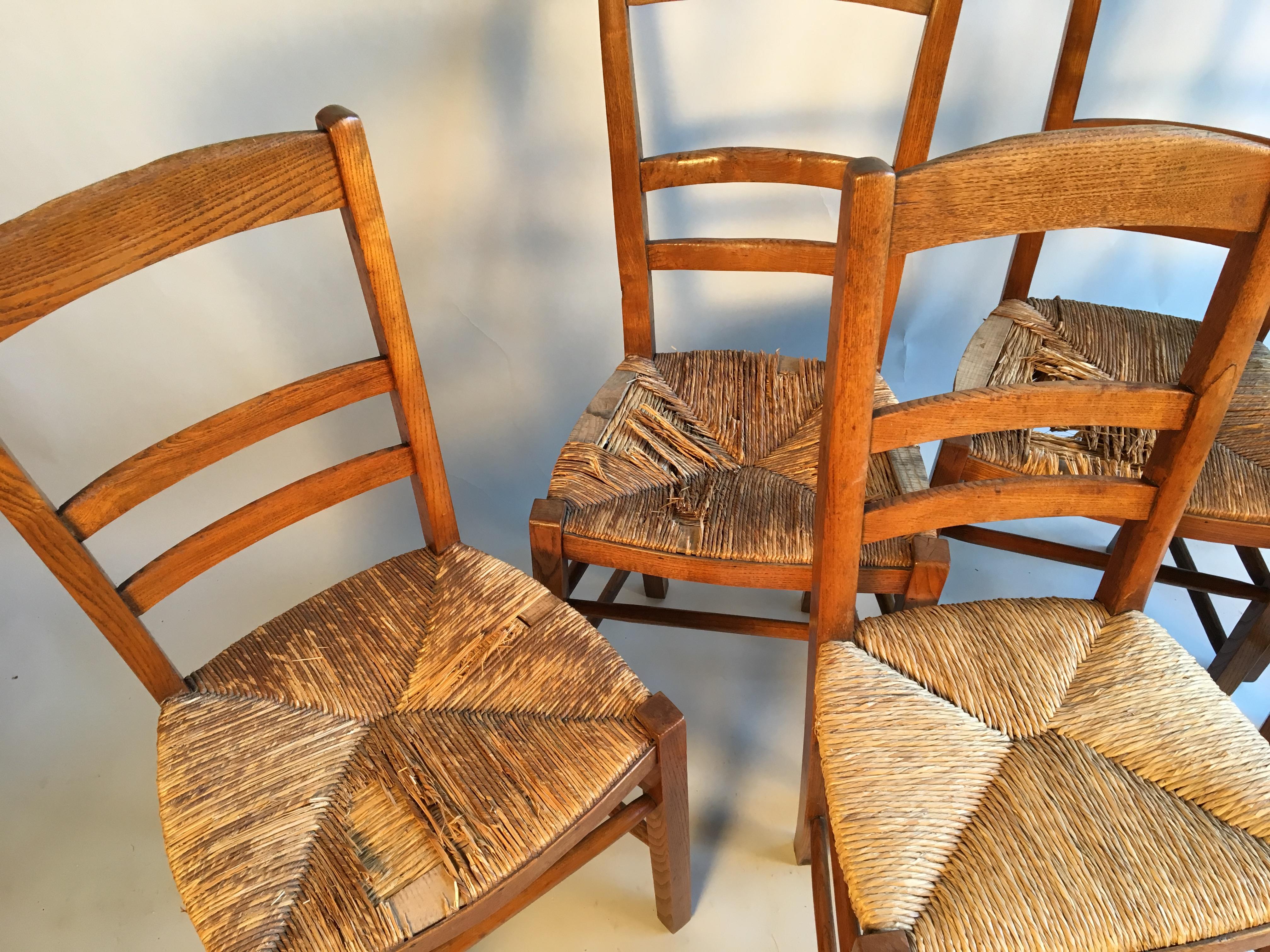 A set of 6 French Country ladder back chairs in elm with rush seats.
