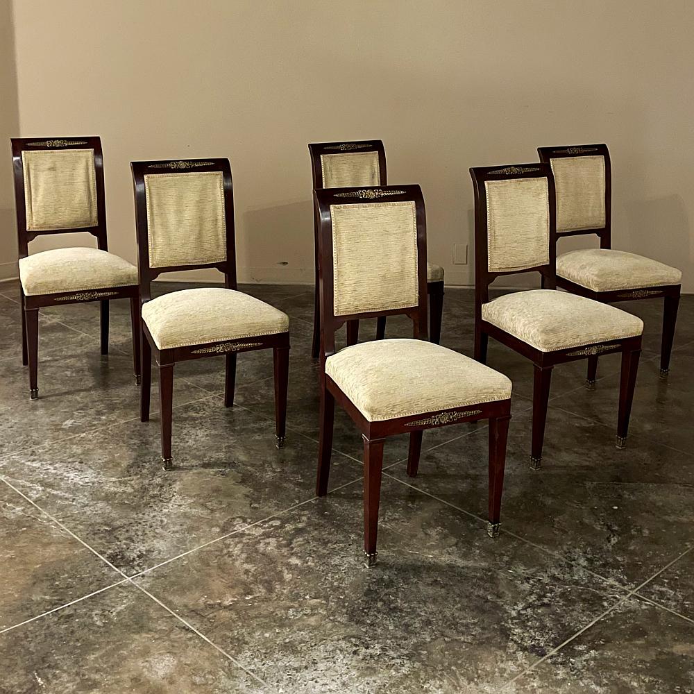Die 6 französischen Empire-Esszimmerstühle aus Mahagoni mit Bronzebeschlägen sind ein stilvoller Ausdruck des Genres. Exotisches importiertes Mahagoni wird verwendet, um maßgeschneiderte Rahmen zu schaffen, wobei die reiche, tief ochsenblutrote
