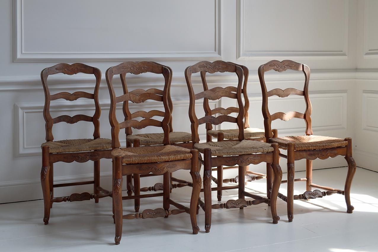 A set of six early 20th-century French chairs in the style of Louis XV. Crafted from solid walnut wood with a warm, aged patina, these chairs exhibit the elegant curves and detailing typical of the Louis XV aesthetic. Each chair features a